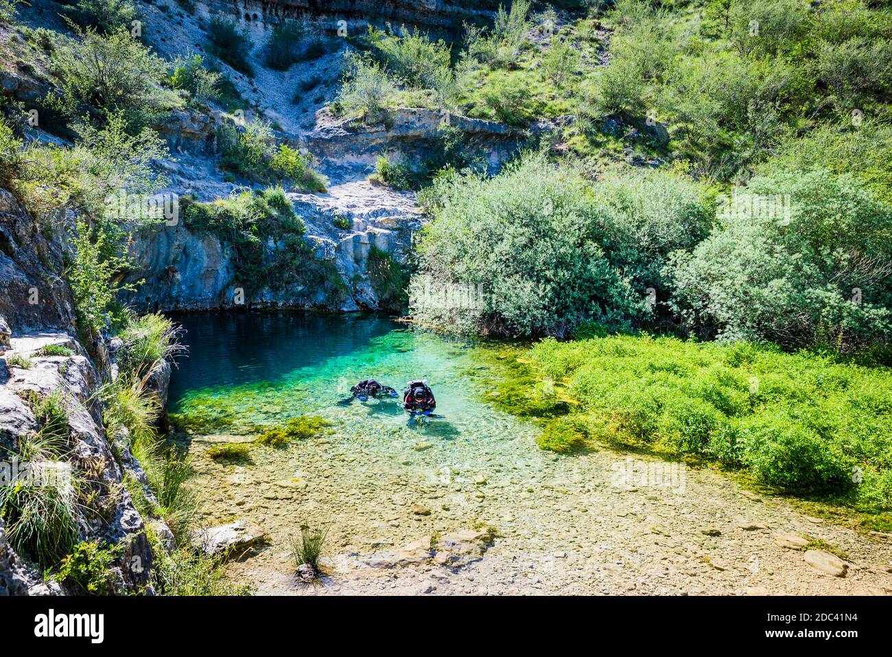 Divers in Pozo Azul. Underwater Speleology. Pozo Azul is a spring or upwelling of water located in the Burgos town of Covanera. Covanera, Tubilla del Stock Photo