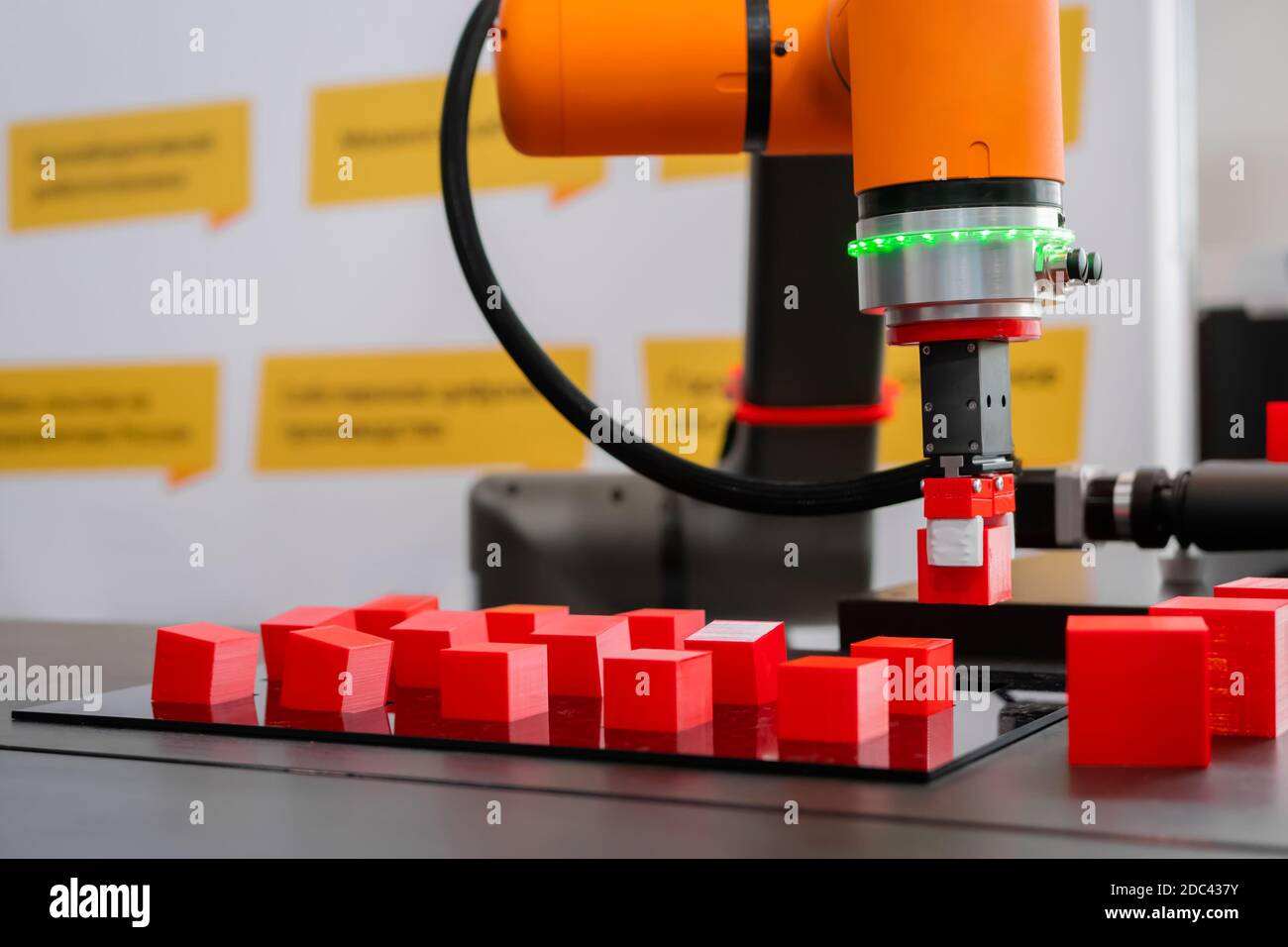 Pick and place robotic arm manipulator moving red toy blocks at robot exhibition Stock Photo