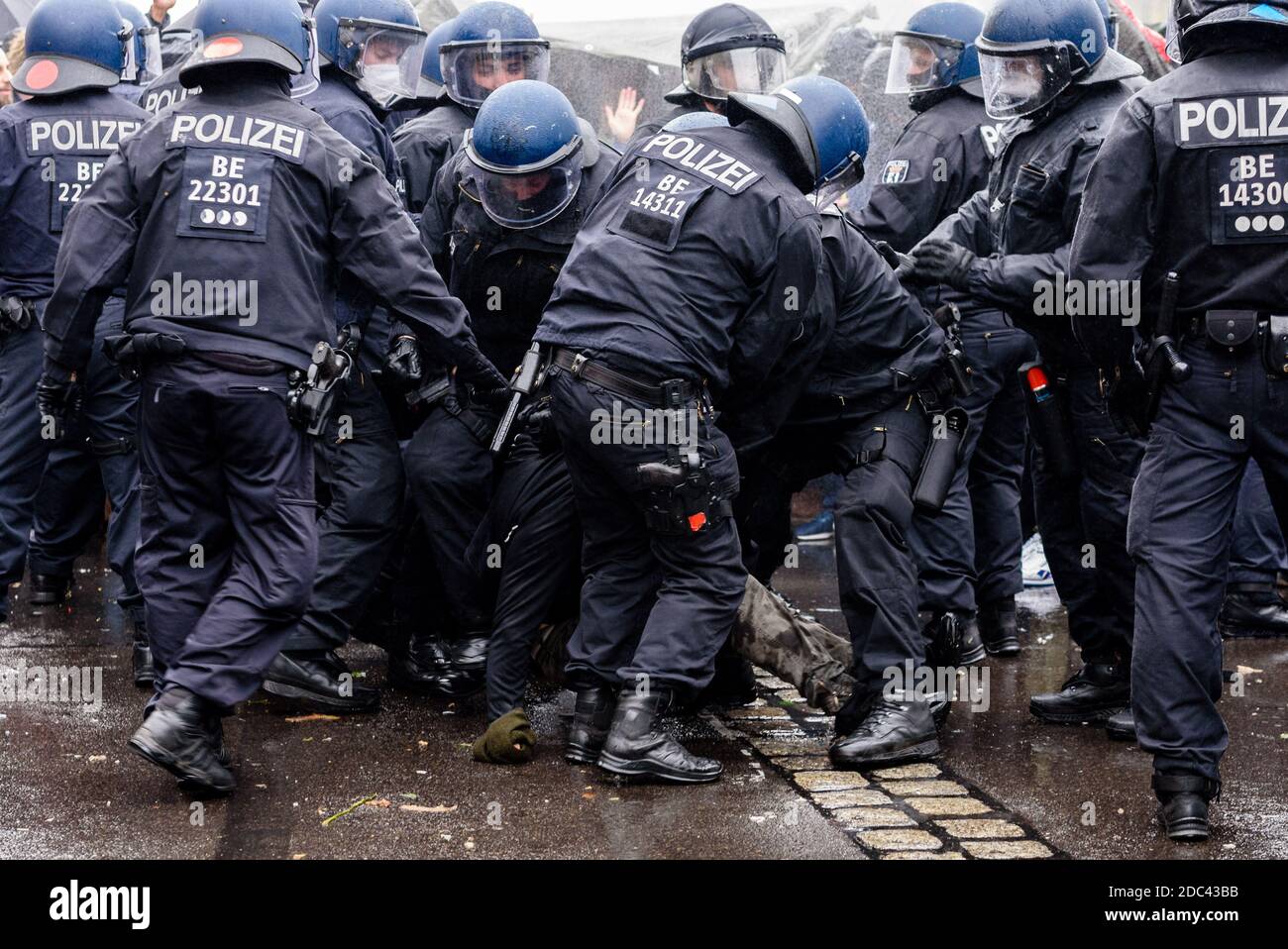 Berlin, Germany. 18th Nov, 2020. Germany, Berlin, November 18, 2020: Police officers try to displace protesters during the use of water cannons in front of Brandenburg Gate after heterogeneous groups around Corona deniers, conspiracy theorists and right-wing extremists called for blocking access to German Government Buildings. Both the Bundestag and the Bundesrat vote on planned new regulations of the infection protection law on November 18, 2020. (Photo by Jan Scheunert/Sipa USA) Credit: Sipa USA/Alamy Live News Stock Photo