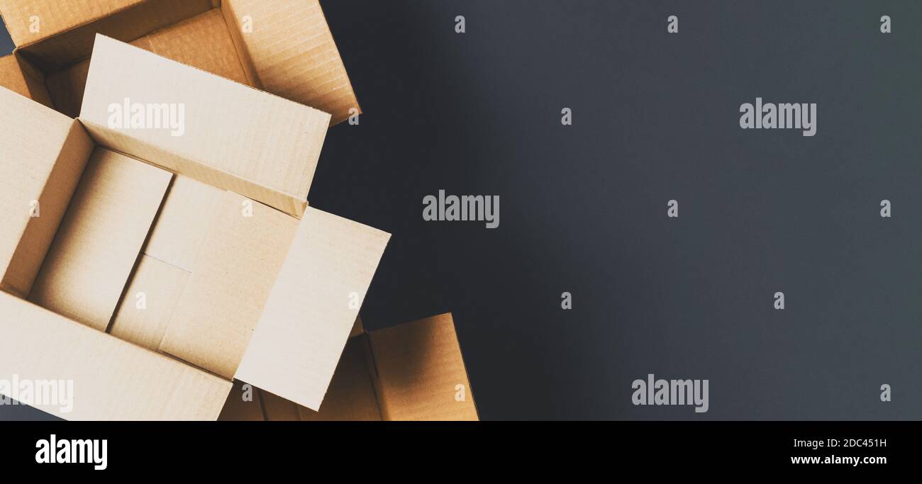 Empty open brown cardboard boxes on dark gray color background. Top ...