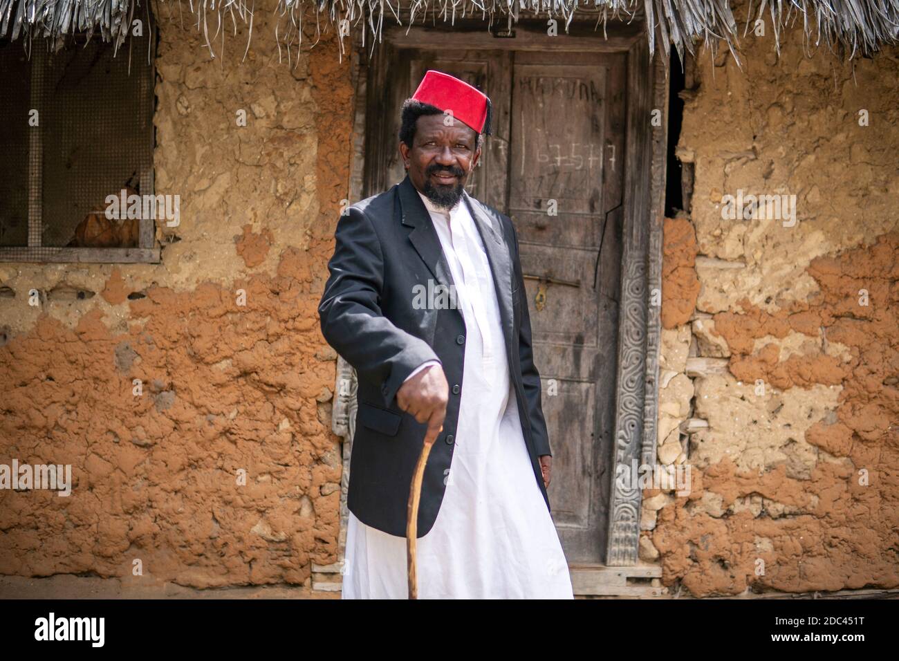 An African Older Man in Red Muslim Taqiyyah Fez Hat And Blazer