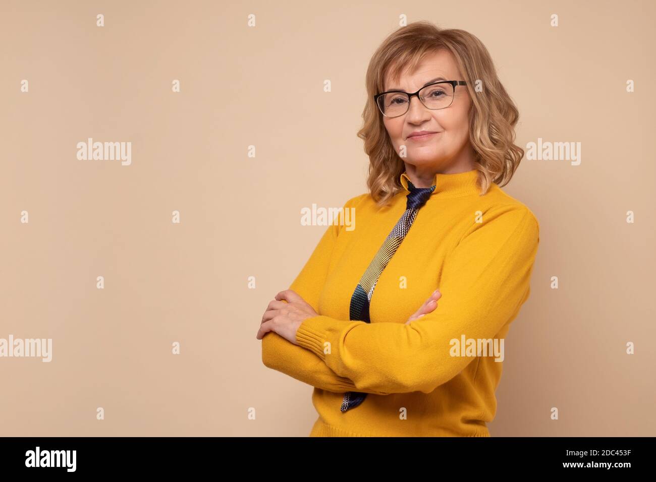 Smiling mature business woman in glasses with folded hands Stock Photo