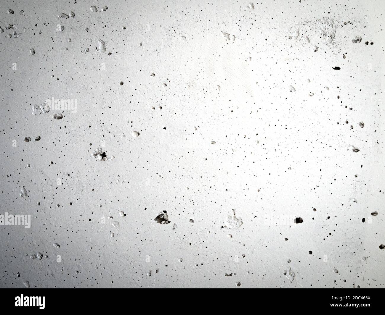 Concrete wall with irregularities painted with gray paint. Abstract gradient building surface background. Stock Photo