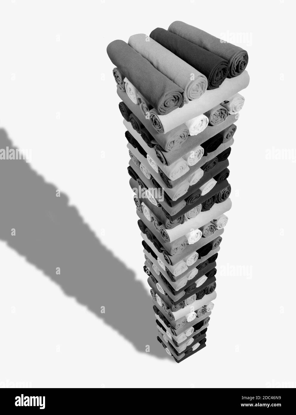 Stack of assorted t-shirts.  Extreme perspective in this photograph of rolled shirts in solid black & white. Very graphic with good copy space. Stock Photo