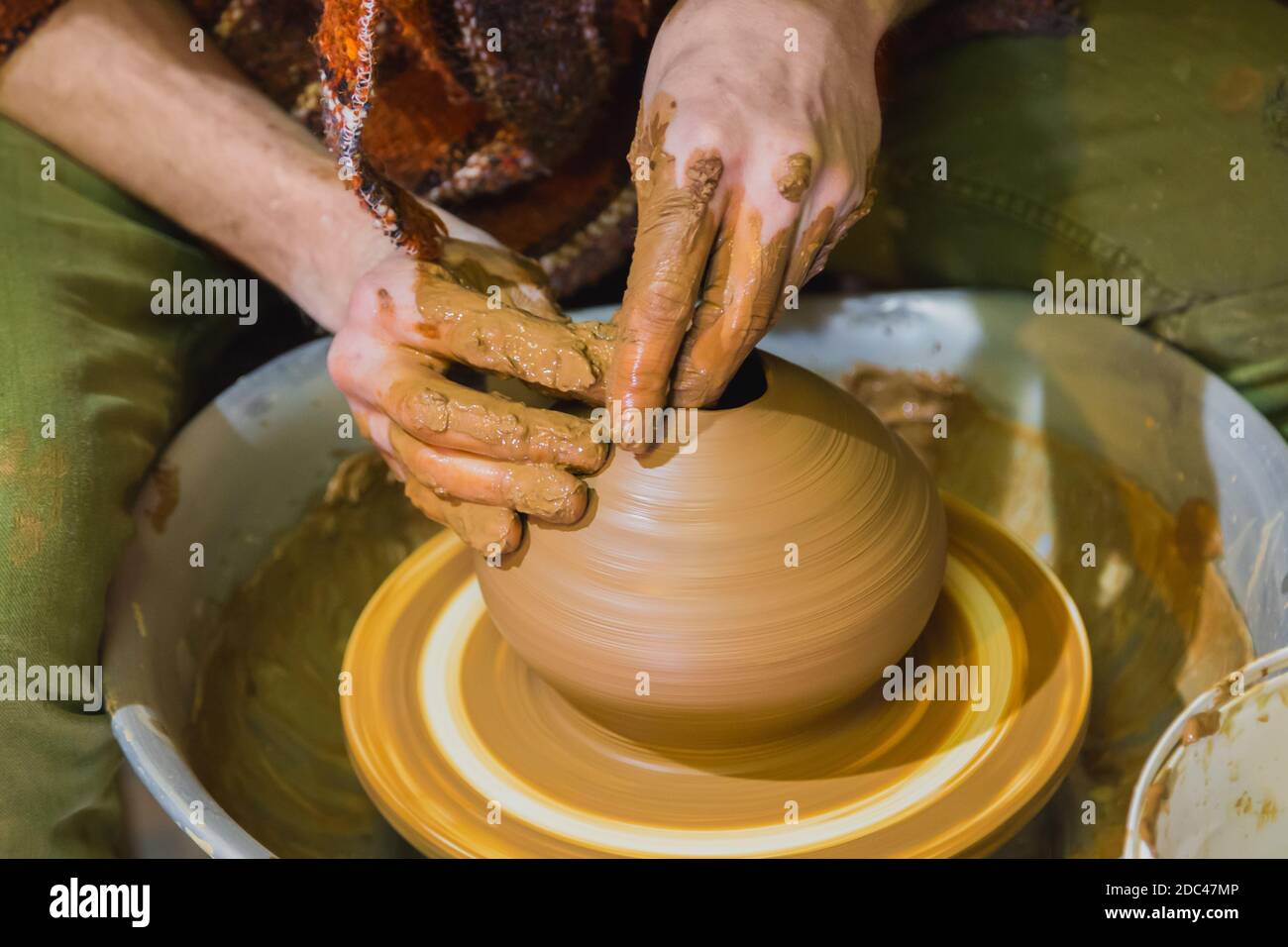 Professional male potter making pot in pottery workshop Stock Photo