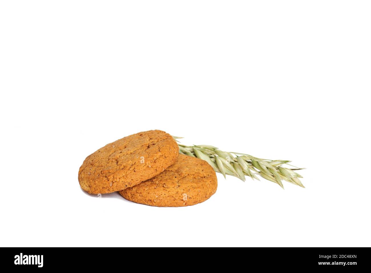 Oatmeal cookies with green ears of oats cut out on a white background. Stock Photo