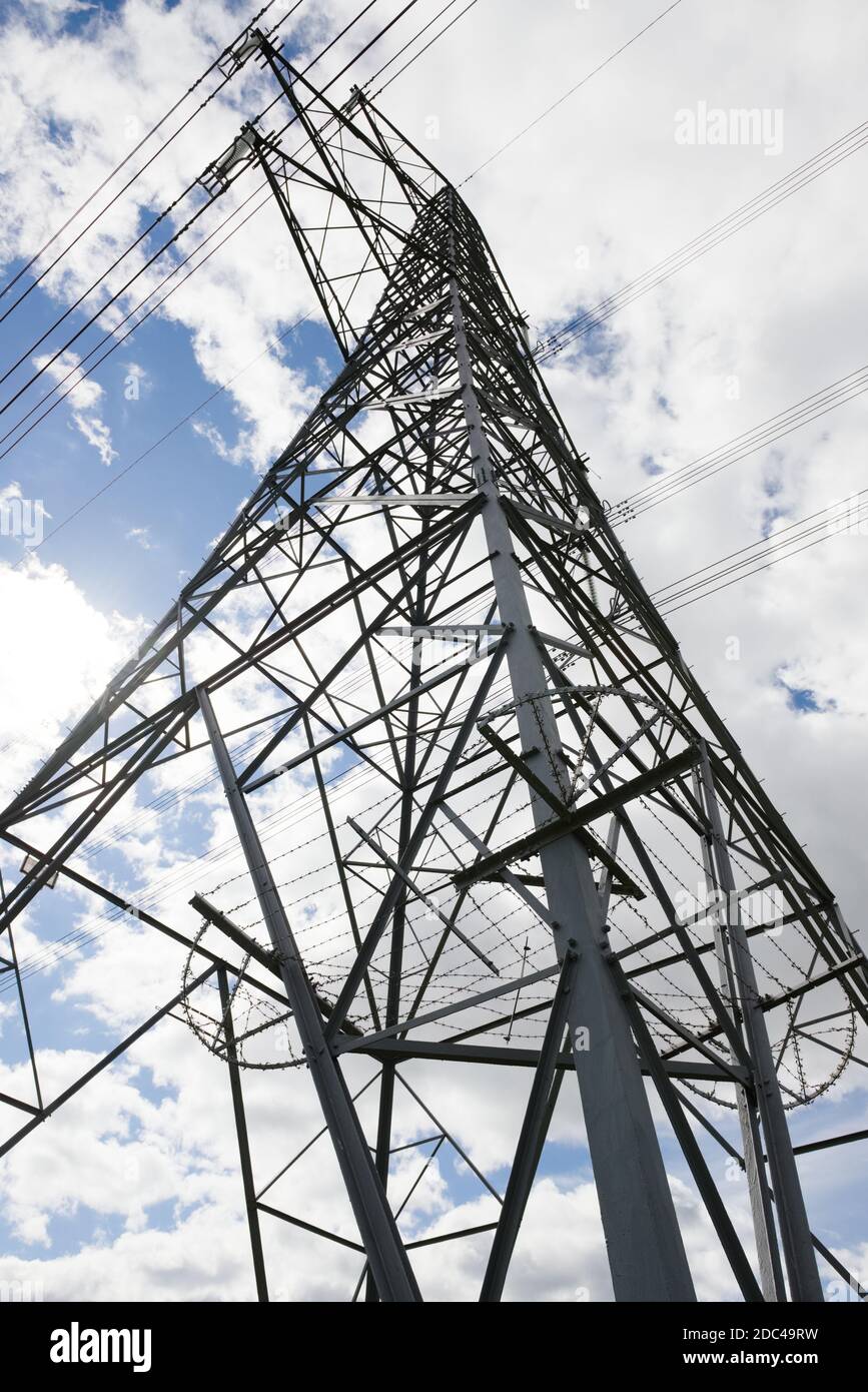 Close up vertical image of the corner of a tall metal electrical transfer tower pylon. Lines of