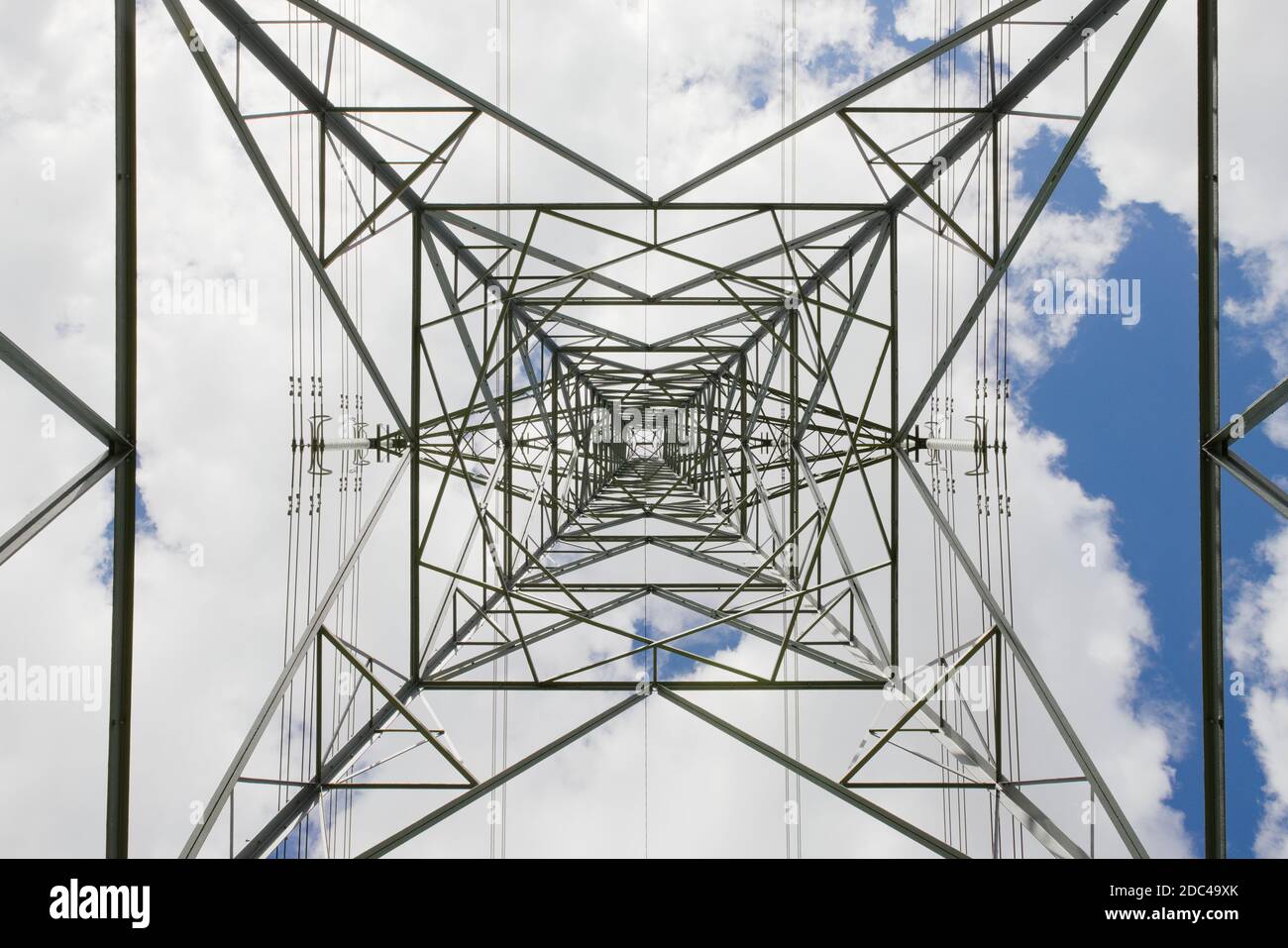 Abstract hard texture from this industrial themed image of an electrical pylon transmission tower. Looking to the sky as the metal converges. Stock Photo