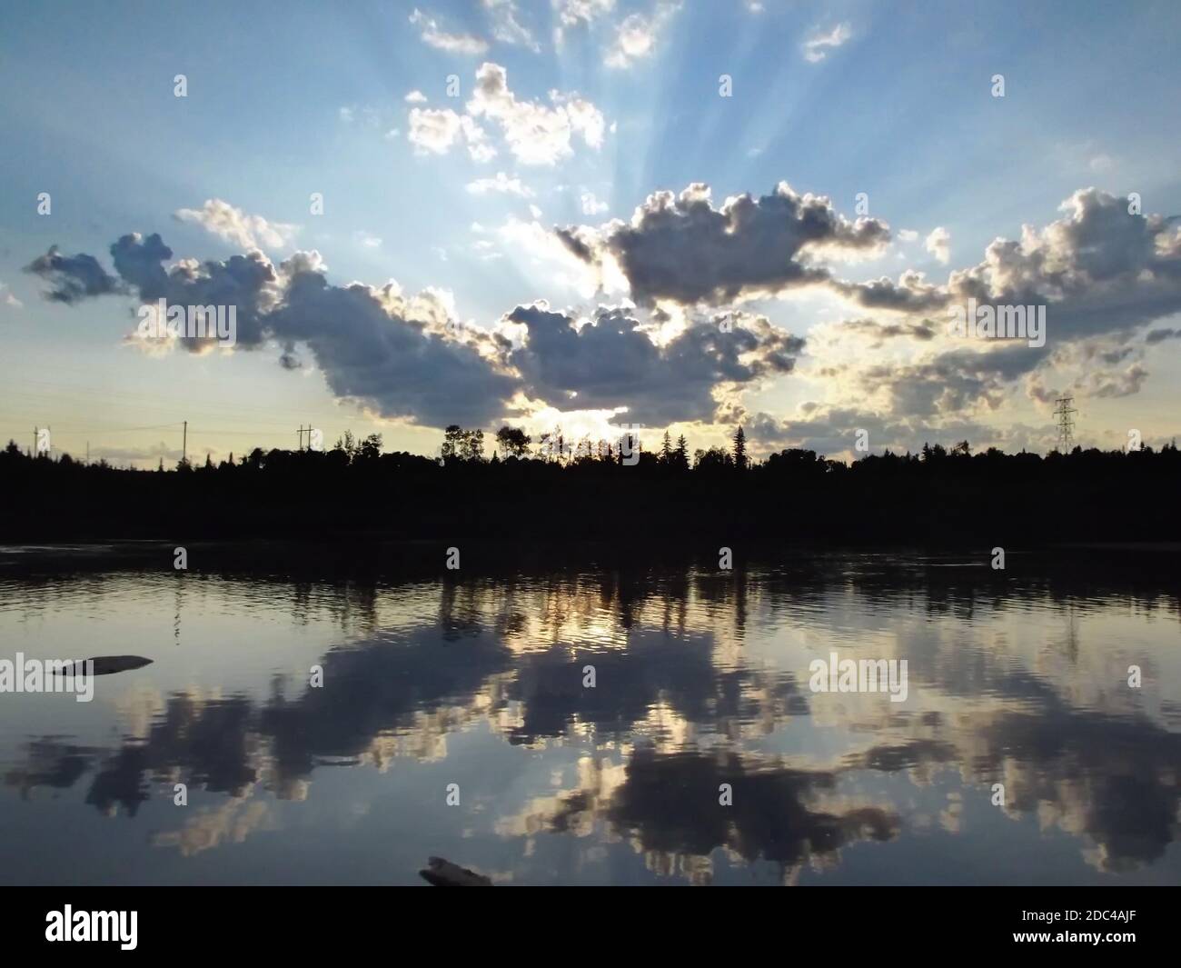 As the sun is setting its lights are reflected on the Kapuskasing River Stock Photo