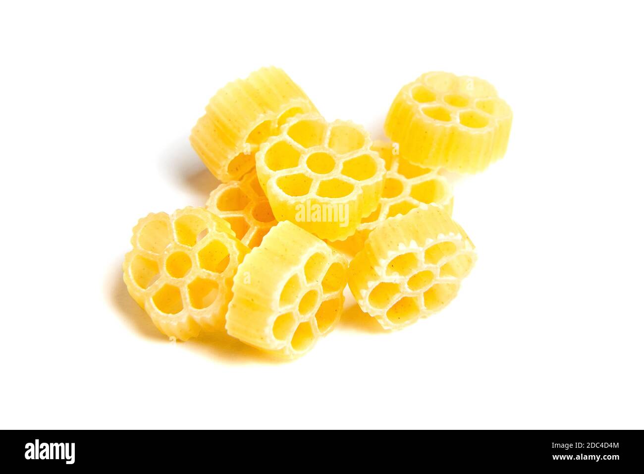 Raw uncooked Rotelle dry italian pasta. Ruote, wagon wheel shaped. Heap, isolated on white background Stock Photo
