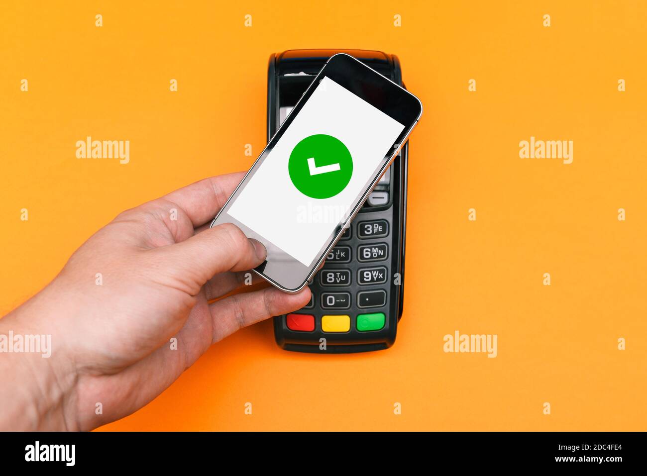 Electronic payment Pos terminal. The client holds the phone for payment. Successful checkout with confirmation on the smartphone screen. Contactless m Stock Photo
