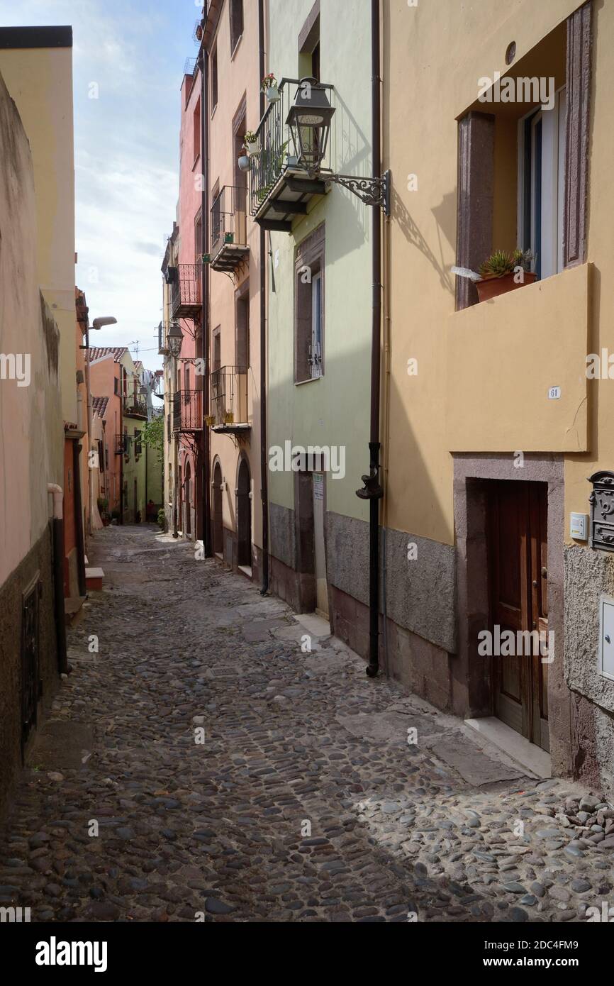 typical narrow alley amidst buildings in Bosa old town Stock Photo
