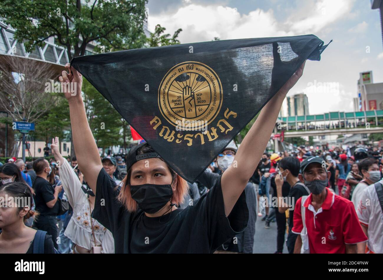 A protester holding a scarf of 'People Party' during the demonstration.Pro-democracy protesters gathered at Ratchaprasong intersection and marched towards the royal Thai police headquarter to splash colour and water following riot police using tear gas and high-pressure water cannons to prevent protesters from approaching Congress during the constitutional debate. Stock Photo