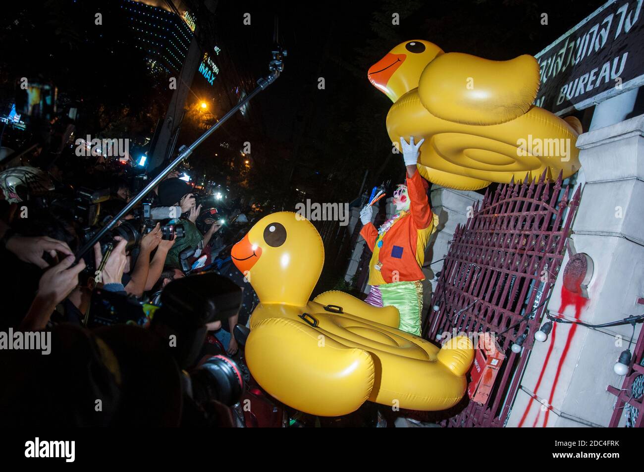 A pro-democracy protester seen with inflatable ducks at the Royal Thai Police Headquarter during the demonstration.Pro-democracy protesters gathered at Ratchaprasong intersection and marched towards the royal Thai police headquarter to splash colour and water following riot police using tear gas and high-pressure water cannons to prevent protesters from approaching Congress during the constitutional debate. Stock Photo