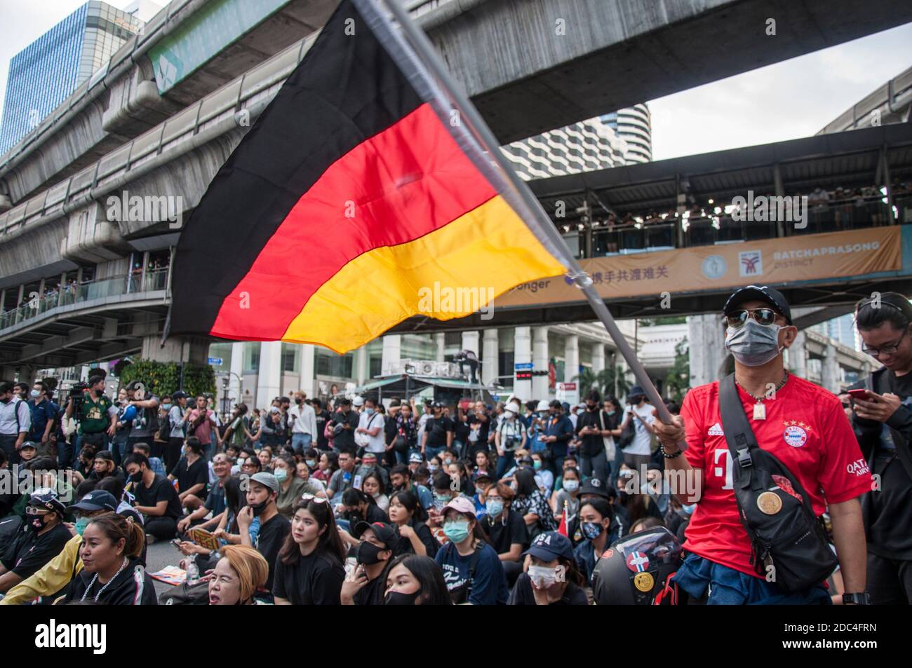 A protester waving a Germany flag during the demonstration.Pro-democracy protesters gathered at Ratchaprasong intersection and marched towards the royal Thai police headquarter to splash colour and water following riot police using tear gas and high-pressure water cannons to prevent protesters from approaching Congress during the constitutional debate. Stock Photo