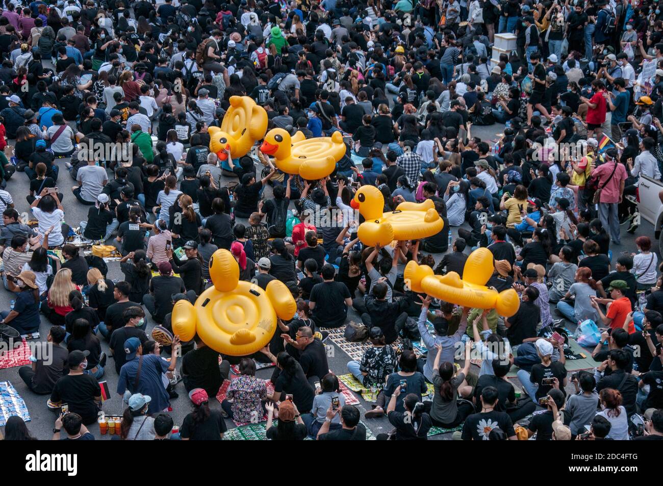 Pro-democracy protesters carrying inflatable ducks during the demonstration.Pro-democracy protesters gathered at Ratchaprasong intersection and marched towards the royal Thai police headquarter to splash colour and water following riot police using tear gas and high-pressure water cannons to prevent protesters from approaching Congress during the constitutional debate. Stock Photo