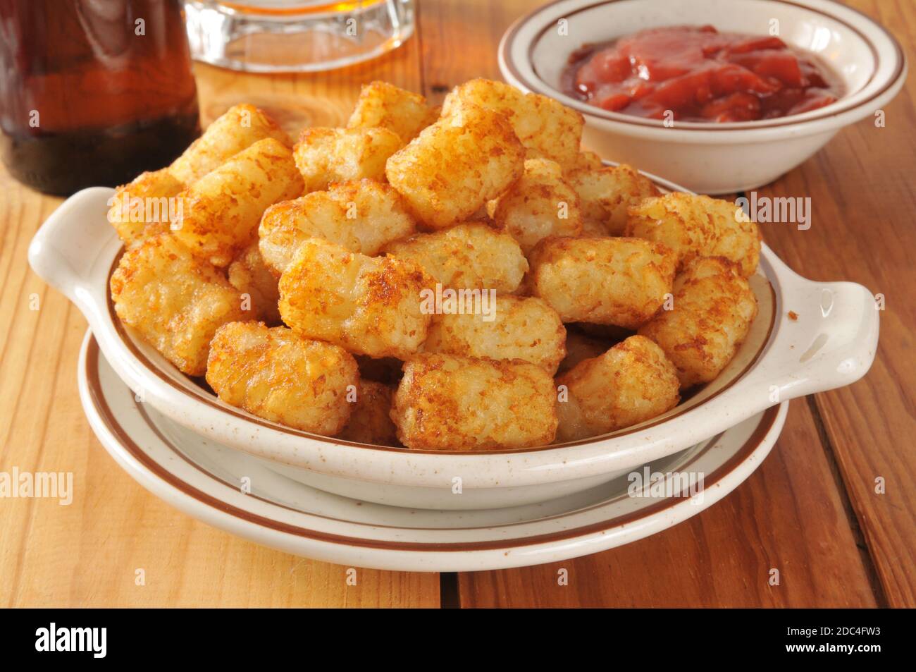 A bowl o golden tater tots served with beer Stock Photo Alamy