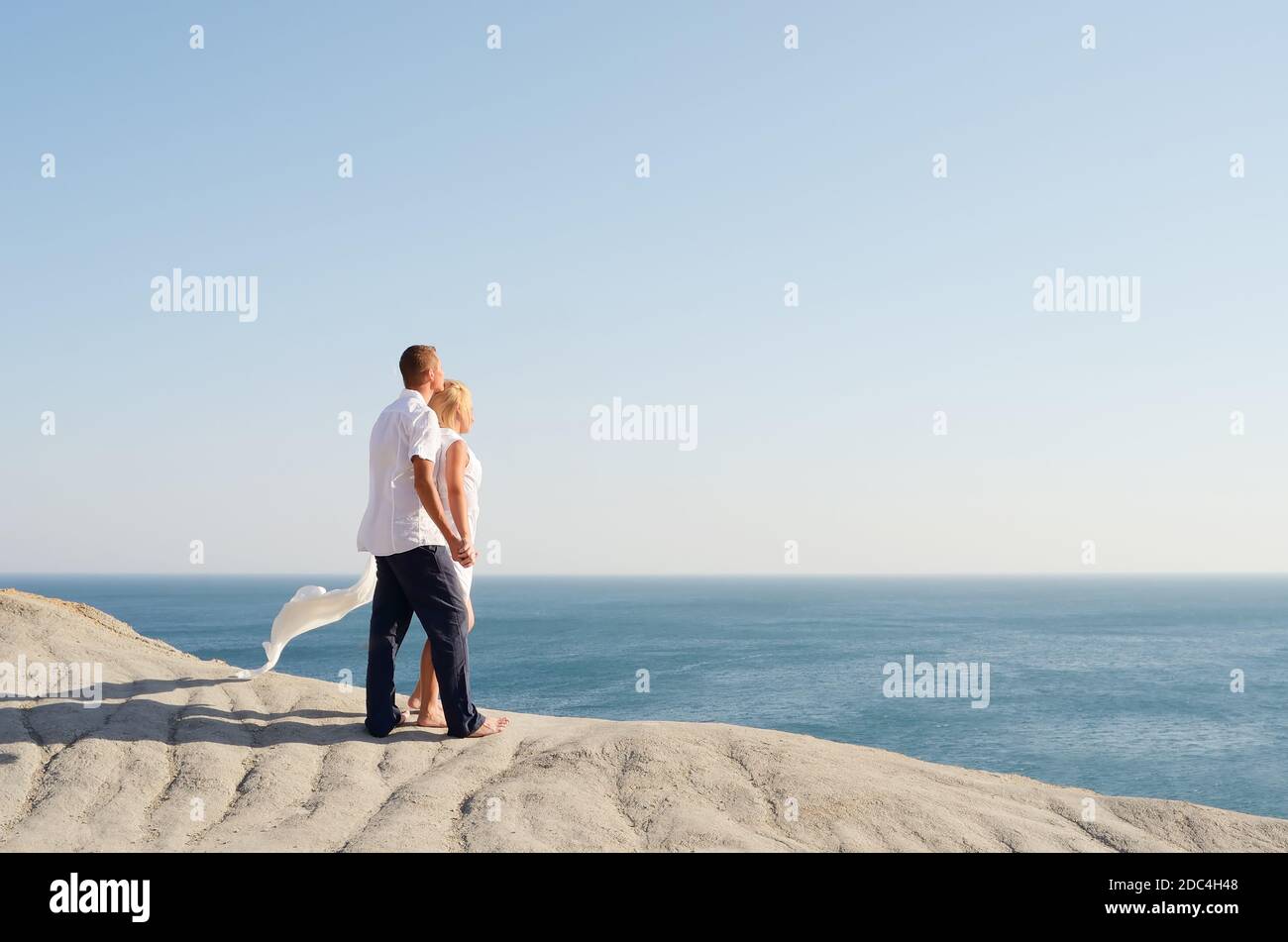 Couple in love looking at the sea holding hands Stock Photo - Alamy