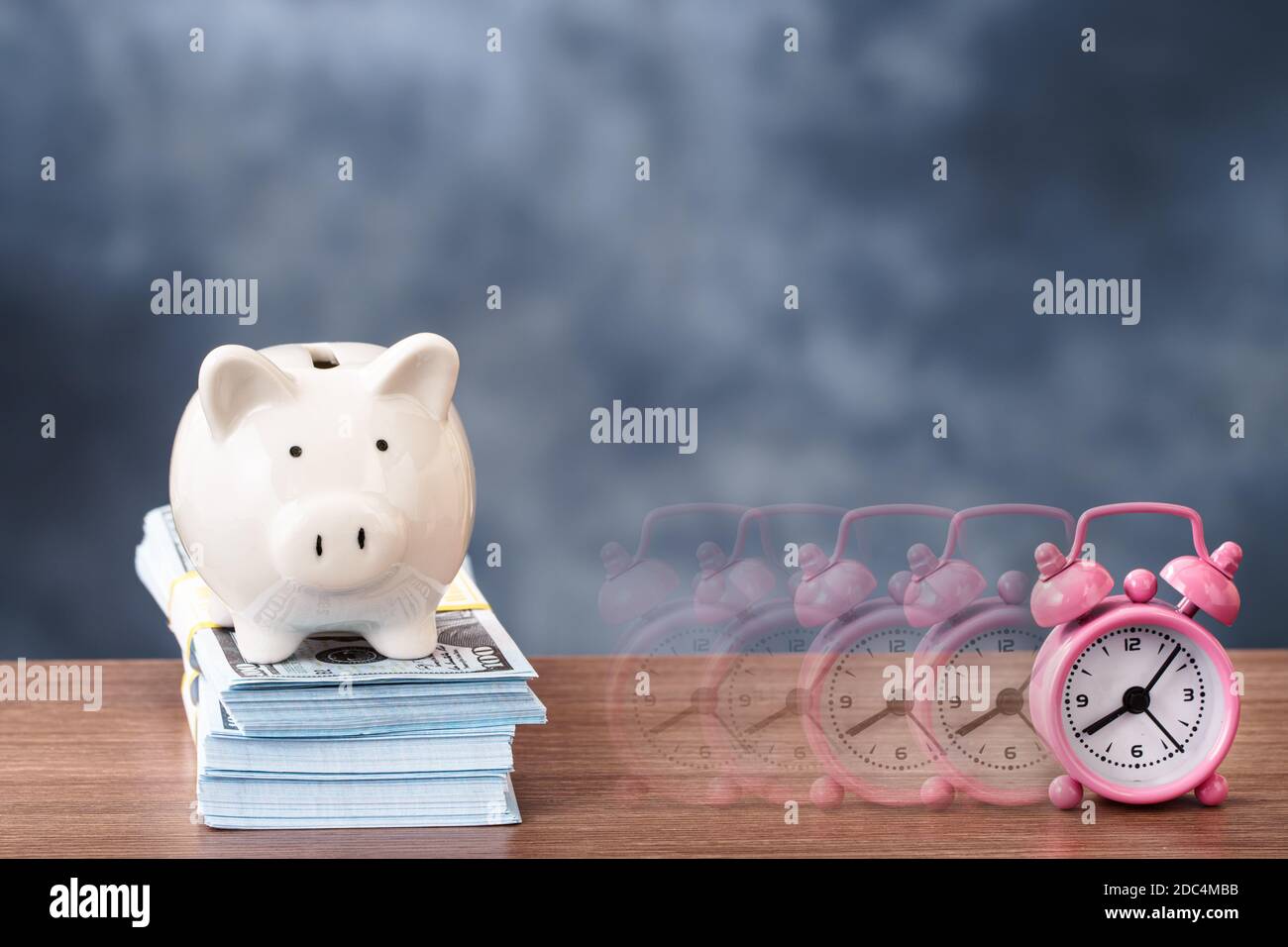 Piggy bank and disappearing alarm clock Stock Photo