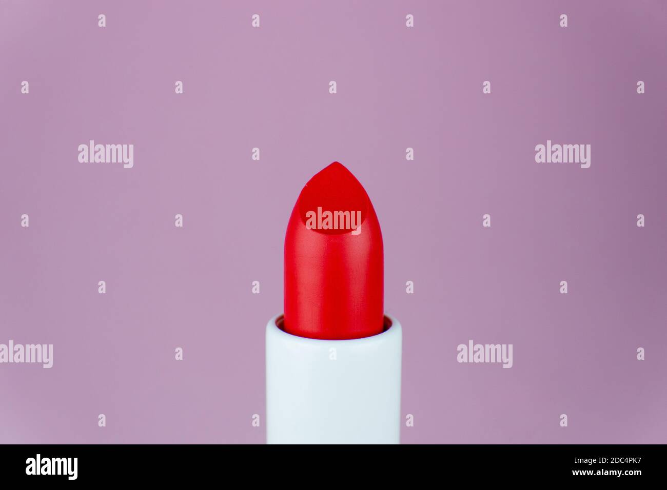 Red lipstick close up shot on purple background. Minimal beauty concept Stock Photo