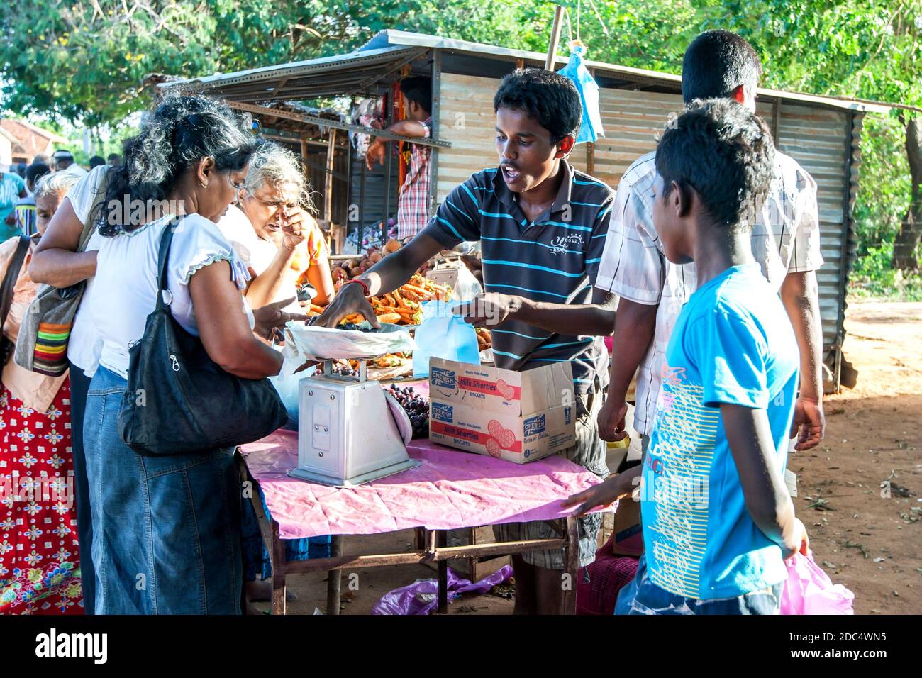 A fruit seller weighs fresh grapes on a scale for a customer at a market near Jaffna in northern Sri Lanka. Stock Photo
