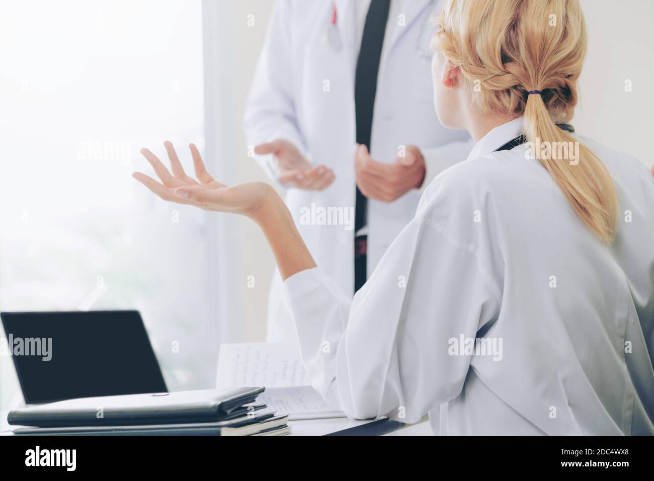 Young female doctor at hospital office having conversation talking with ...
