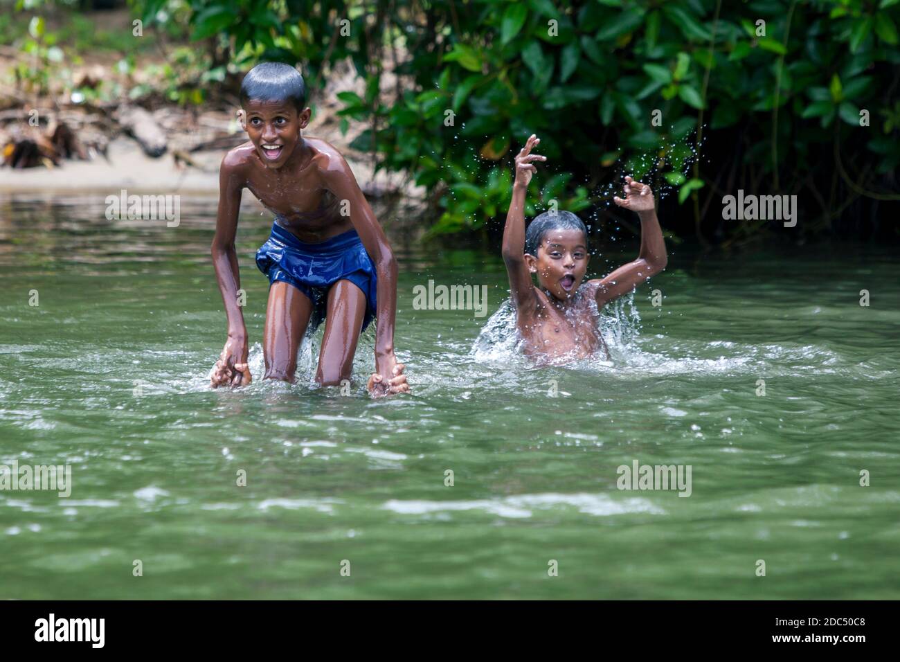 Happy boys playing in the Madu River near Balapitiya in Sri Lanka
