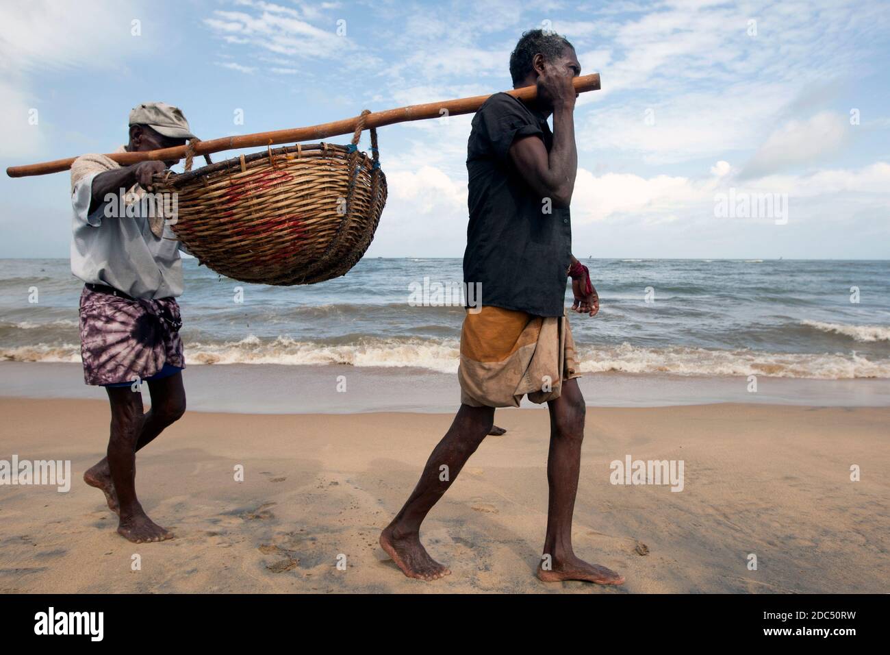 Fishermen carry their catch of fish in a basket towards the Negombo Fish  Market for sale. Negombo is located on the west coast of Sri Lanka Stock  Photo - Alamy