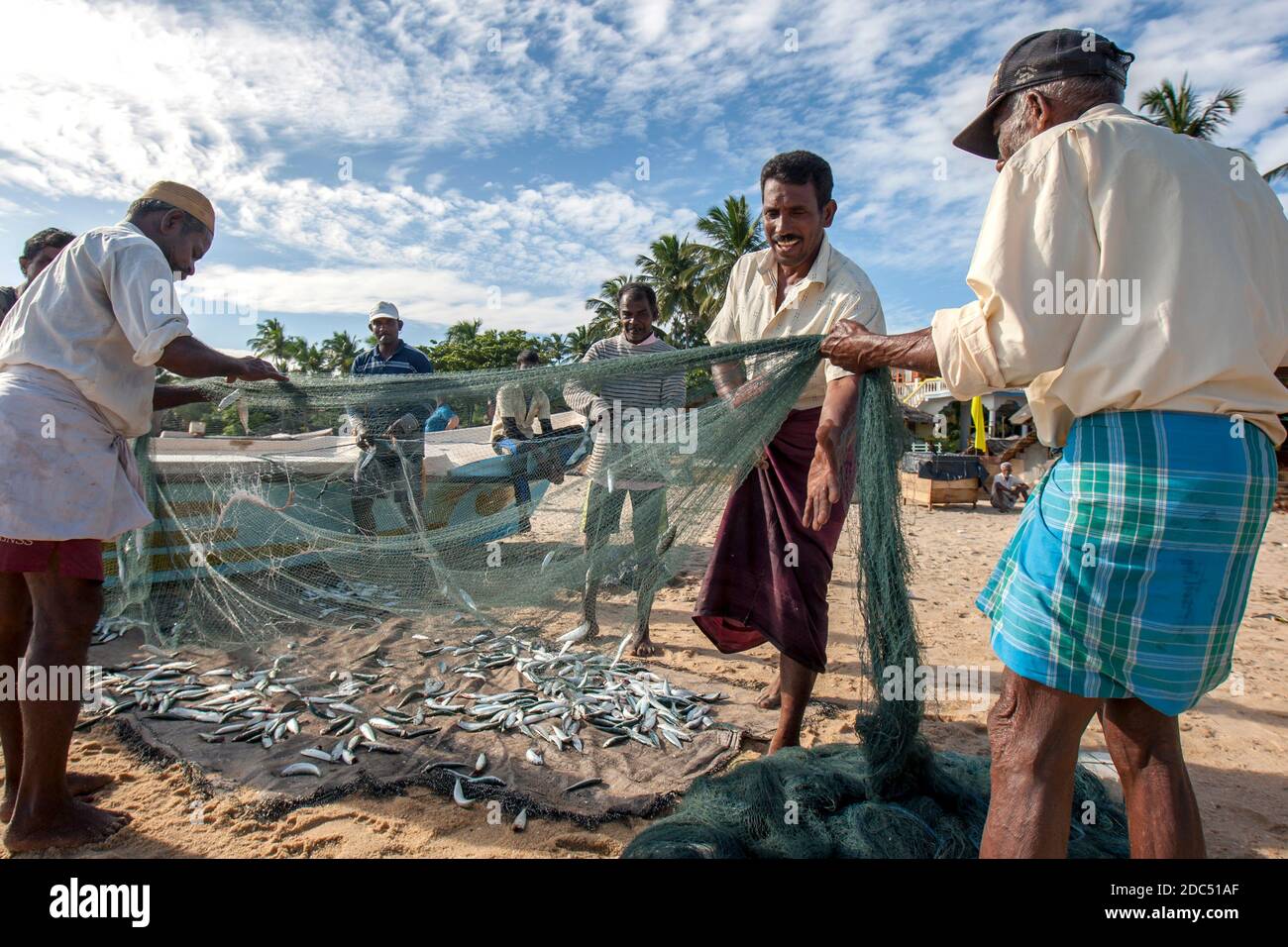 Fishermen remove their catch from their nets on Arugam Bay beach