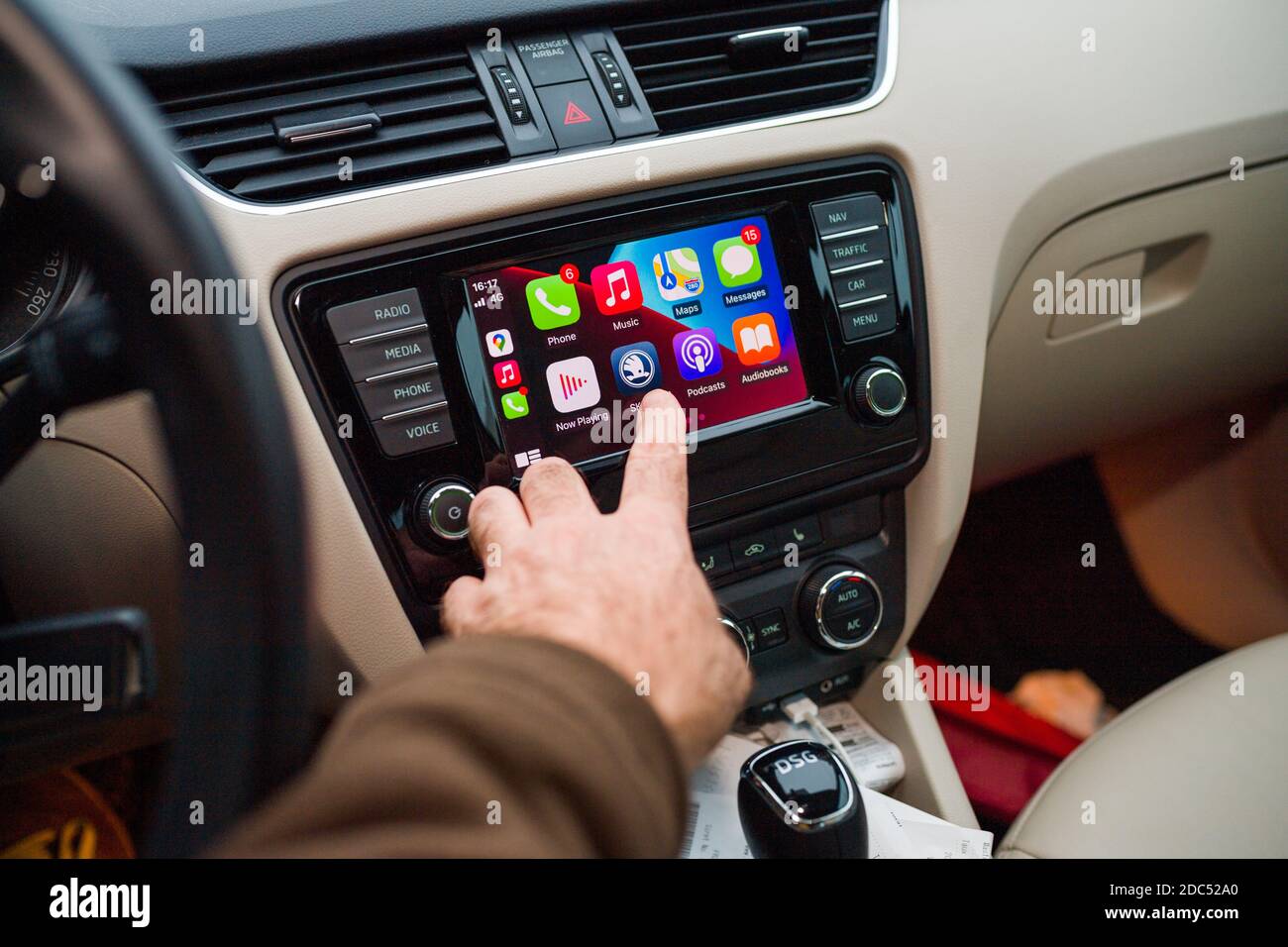 Paris, France - Nov 11, 2020: Male hand pressing icon of Skoda App on infotainment car computer system running Apple Computers CarPlay from iOS iphone device Stock Photo