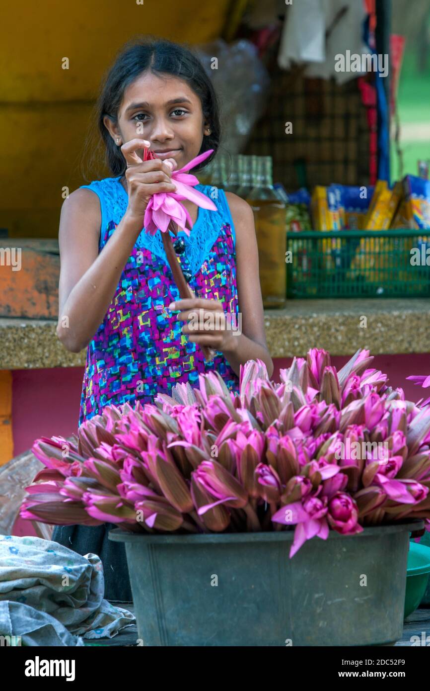 A girl selling lotus flowers at Kataragama temple complex in southern Sri Lanka. Kataragama is sacred to Buddhists, Hindus and Muslims. Stock Photo