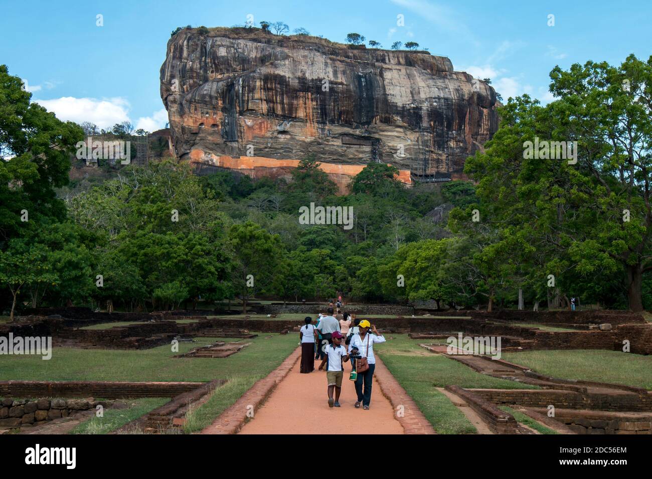 Visitors to Sigiriya Rock Fortress in Sri Lanka walk through the Royal Gardens which were elaborately designed stone and brick structures. Stock Photo