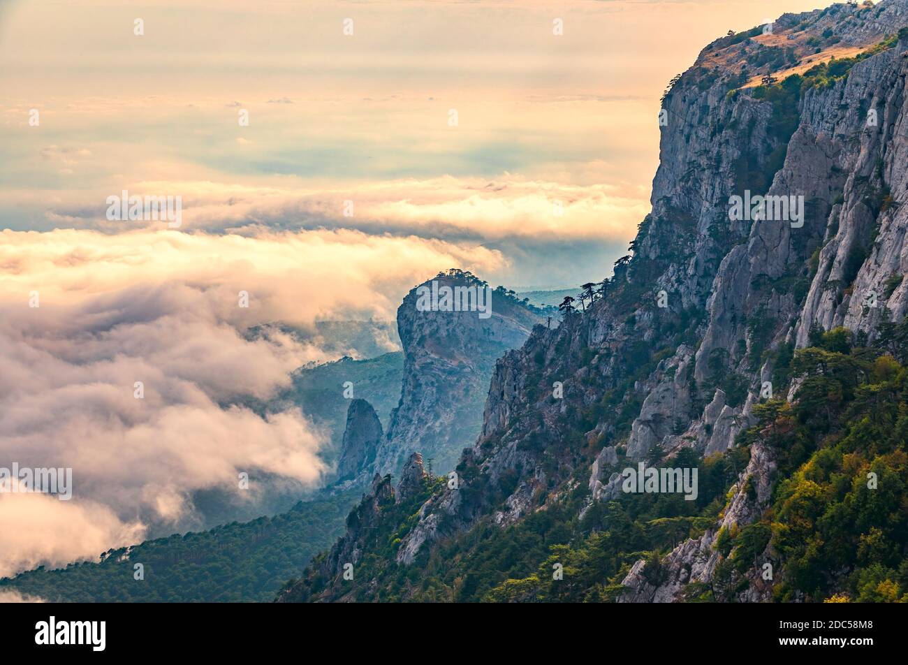 A majestic view of the rocky mountains and the valley in fog and clouds ...