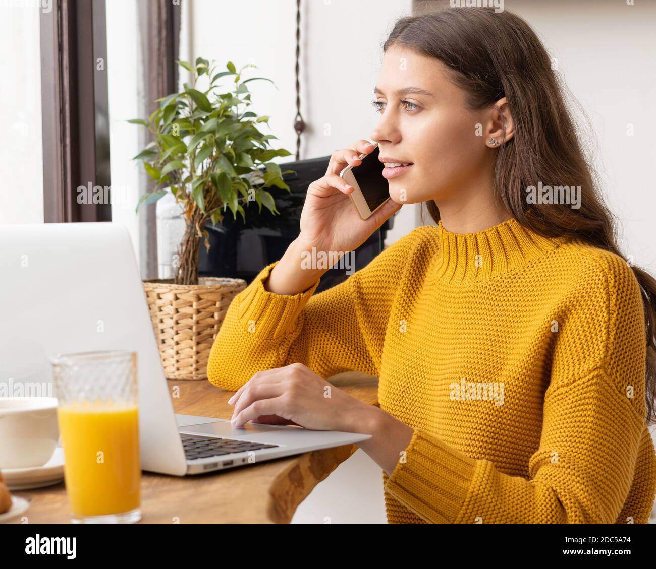 Digital nomad. Young female entrepreneur talking on mobile phone Stock Photo