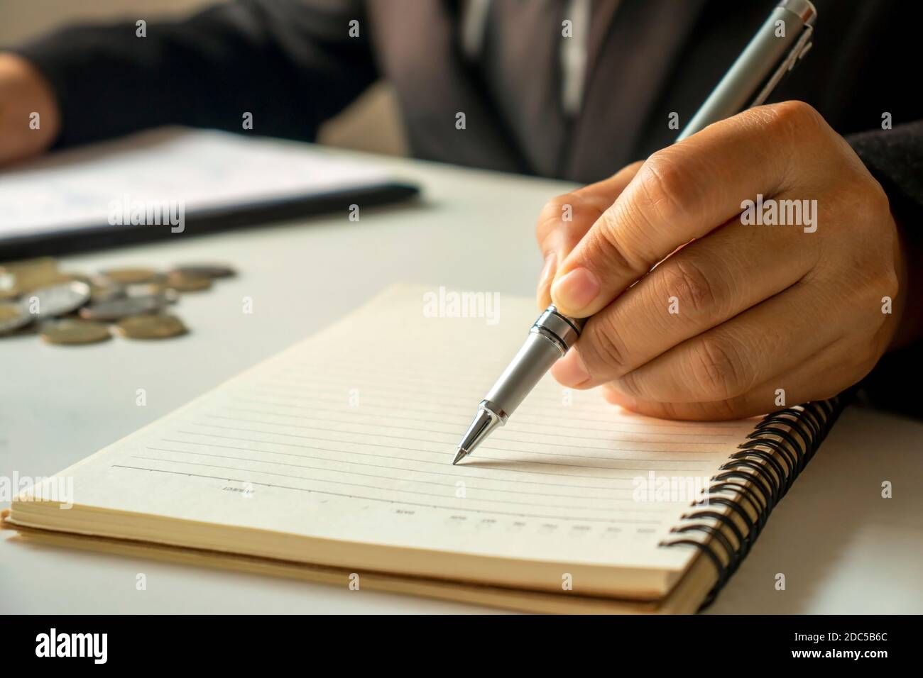 Business people take notes of income and expenses in notebook. Stock Photo