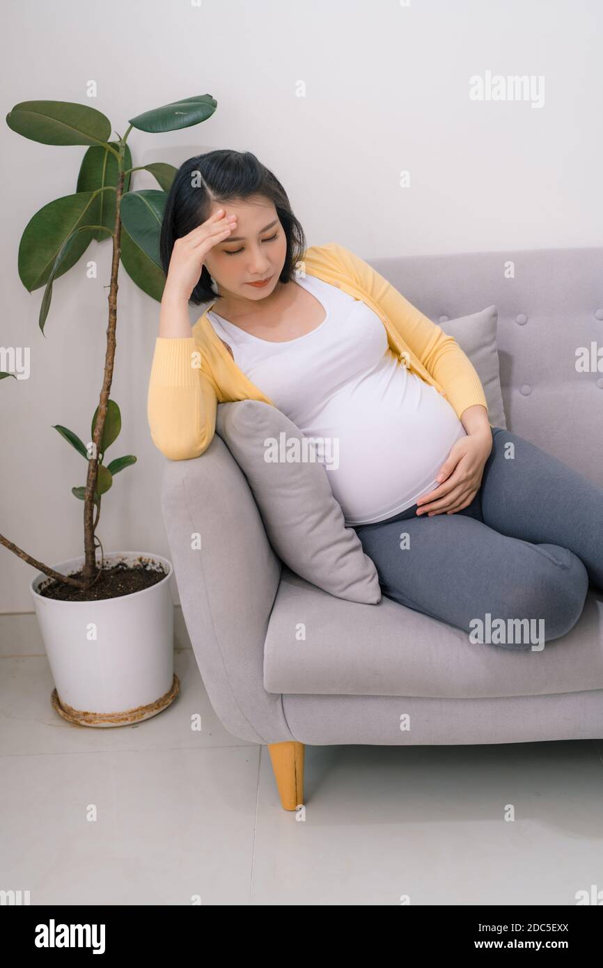 Young expectant, pregnant woman with headache copy space. Stock Photo