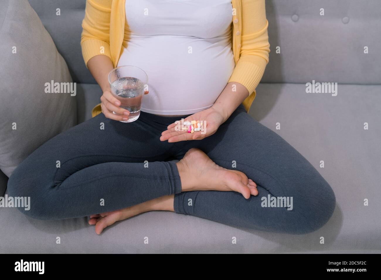 Young pregnant woman taking medicine Stock Photo