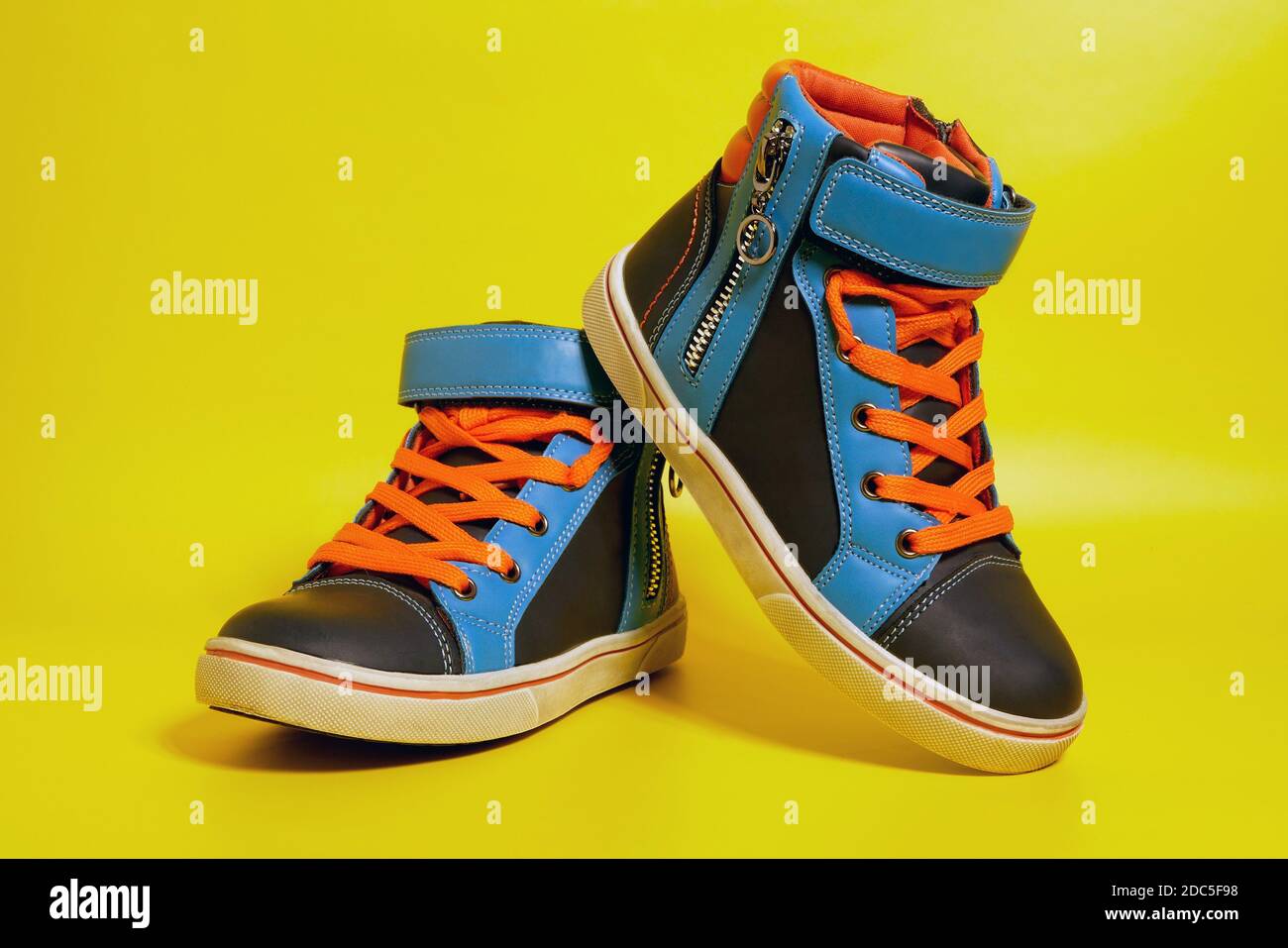 Children's colorful boy shoes on yellow background, kid's fashion Stock