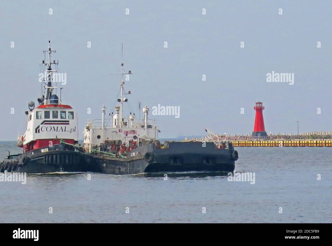 barge entering in the port of Gdansk with a tugboat, Poland Stock Photo