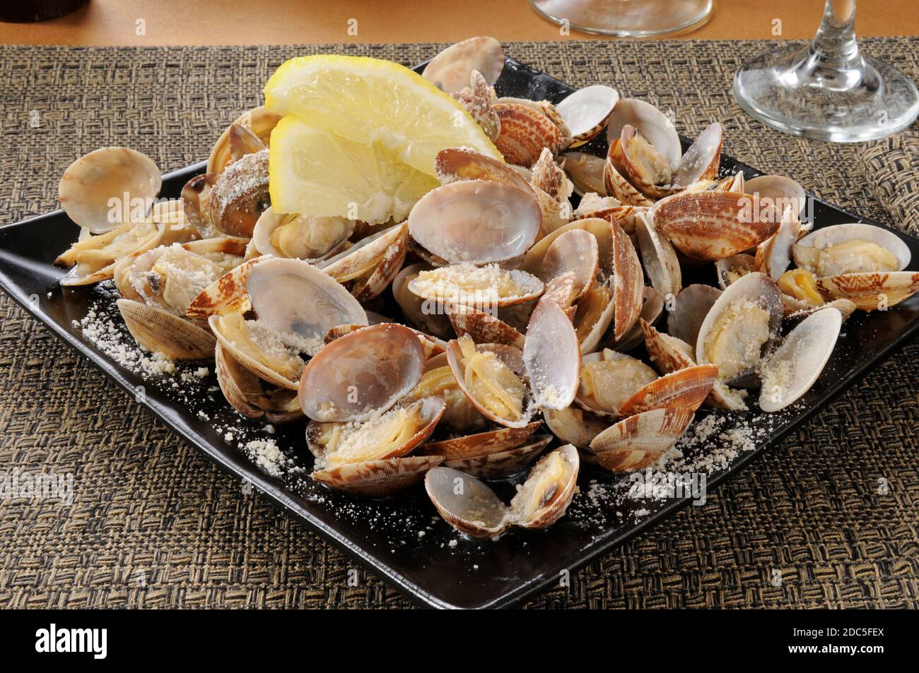 Steamed clams in the shell with parmesan cheese and lemon Stock Photo