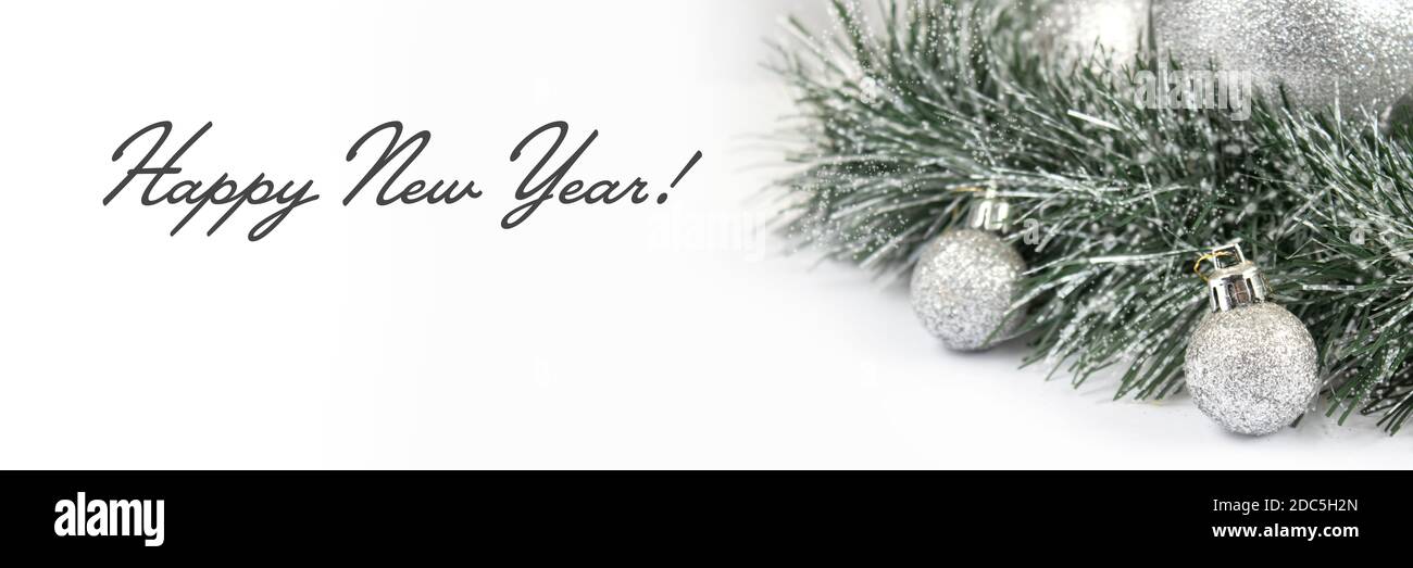 Christmas and New Year banner with green spruce branch and white balls on a white background. Christmas composition with copy space. Stock Photo