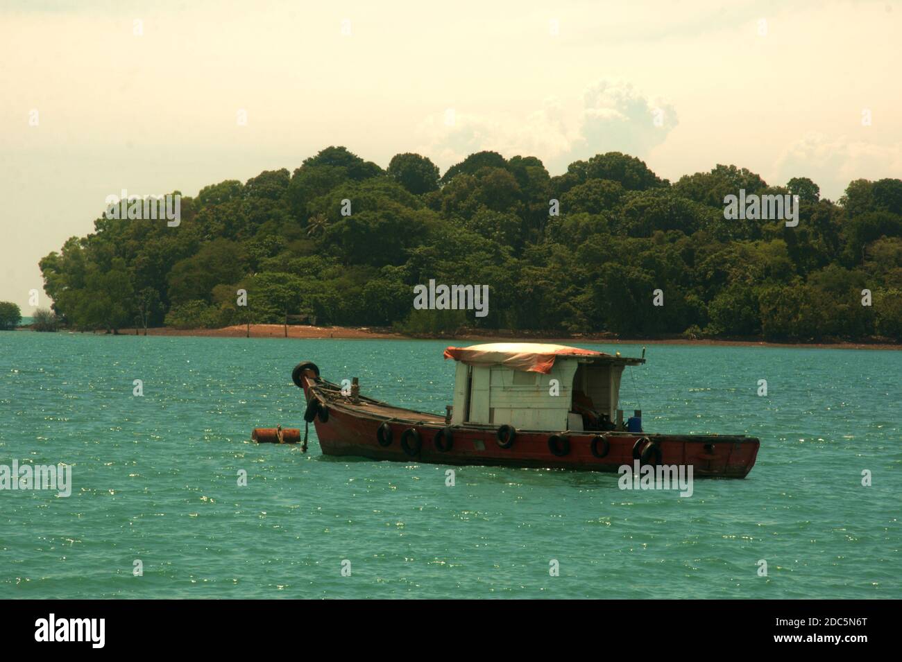 wooden fishing boat resting on the sea in Port Dickson Malaysia Stock Photo