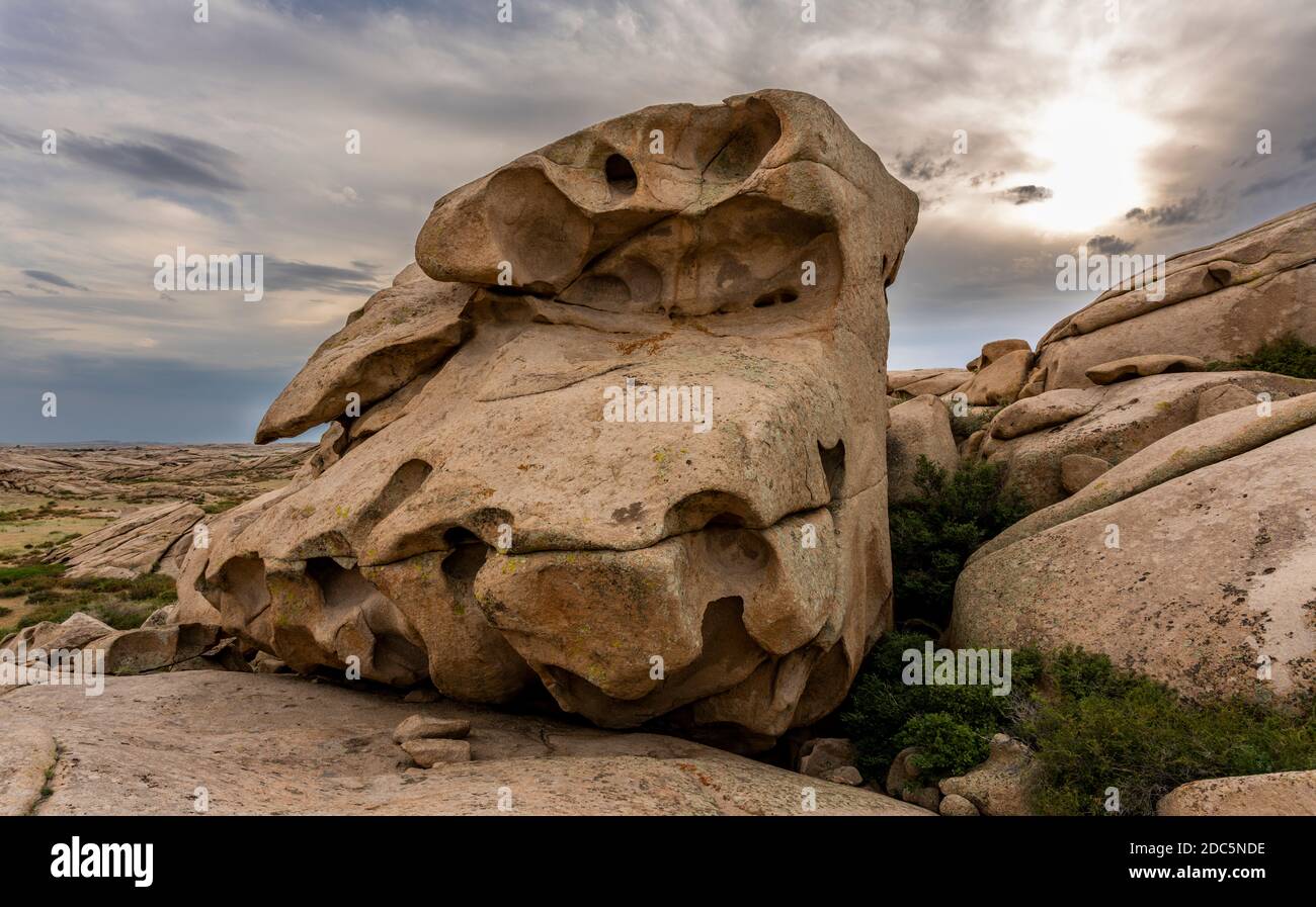 Rock formations in Bektau Ata in Kazakhstan with sun and clouds during sunset. Stock Photo