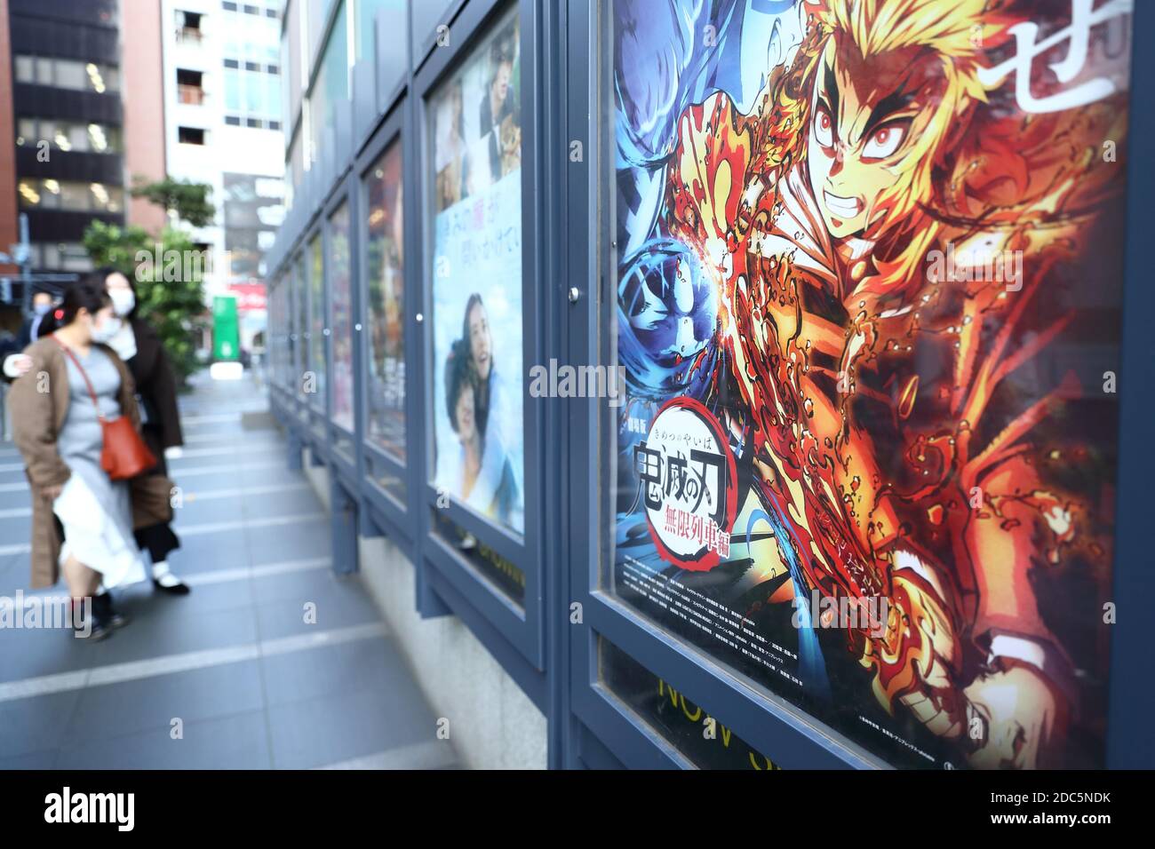 People Walk Past A Poster For An Animated Film Based On Popular Japanese Manga Demon Slayer Kimetsu No Yaiba The Movie Infinite Train On Display Outside A Movie Theater In Tokyo Japan