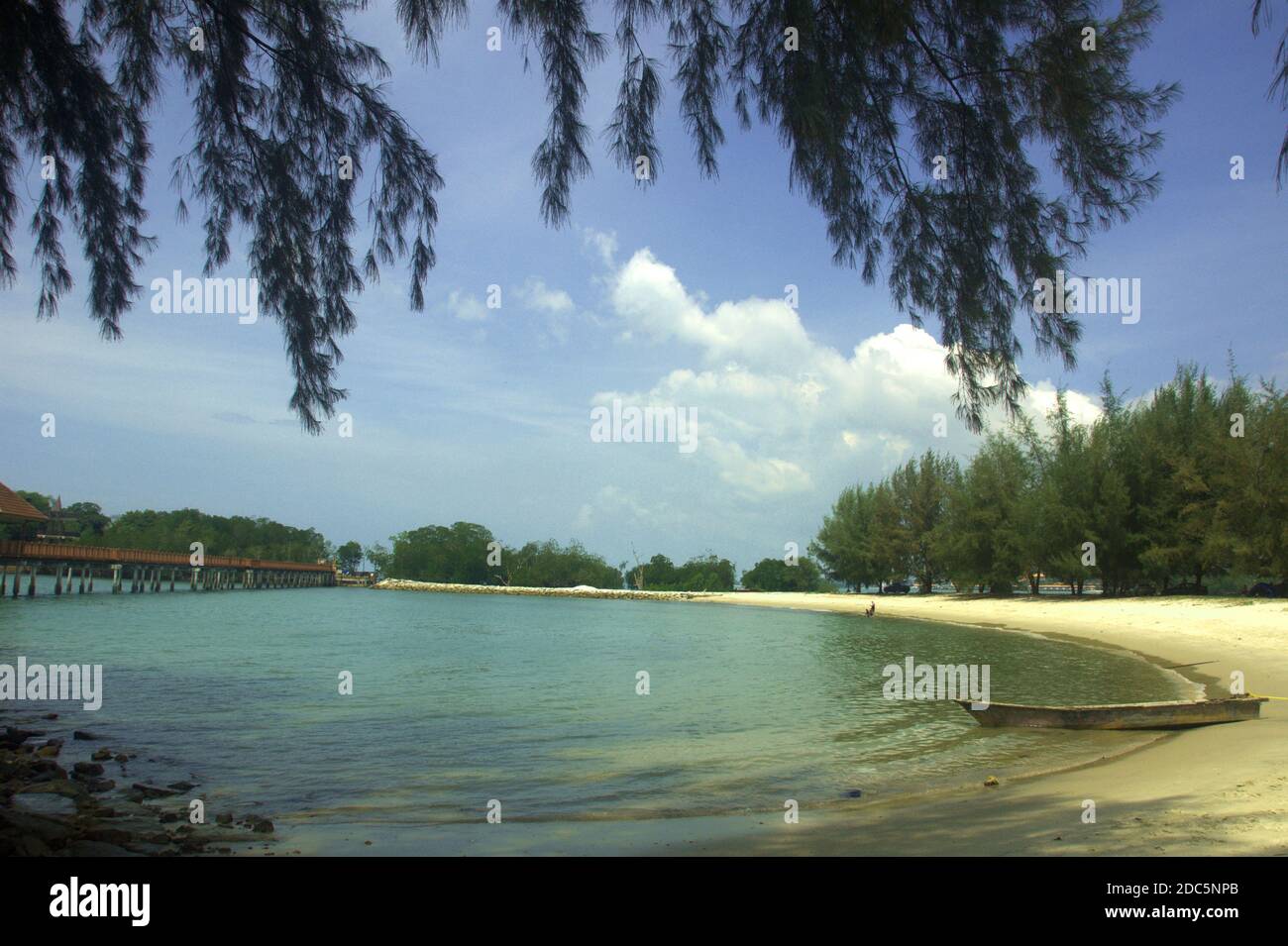 a calm and beautiful lagoon with wooden pedestrian bridge over it in Port Dickson beach Malaysia Stock Photo