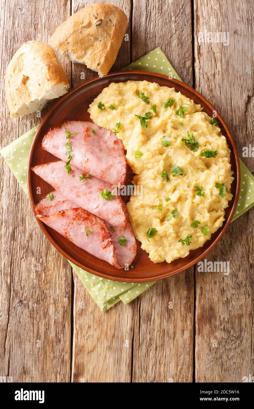 Pease Pudding is an easy, British side dish traditionally serve with ham closeup in the plate on the table. Vertical top view from above Stock Photo