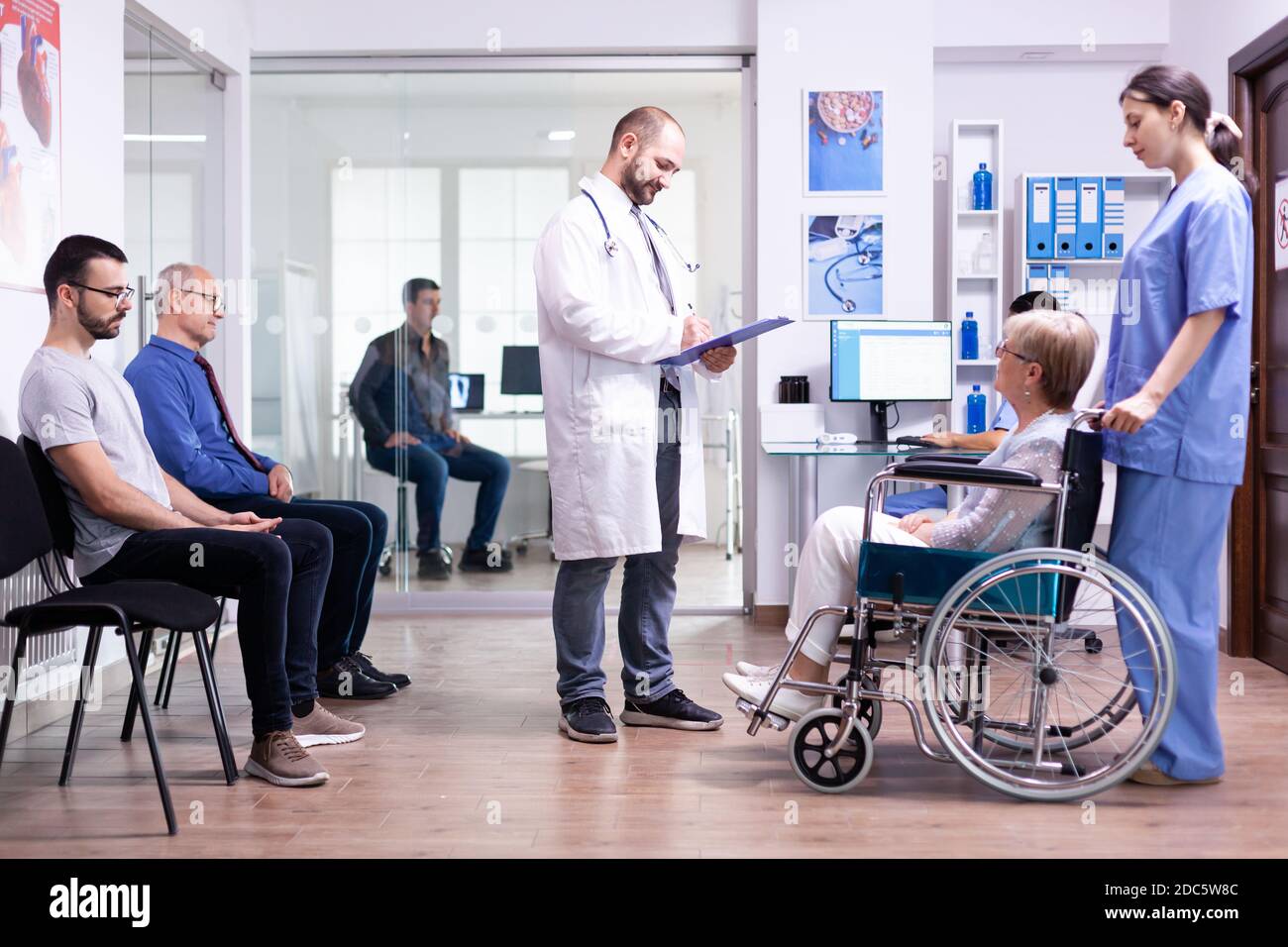 Doctor checking diagnosis of disabled senior woman in wheelchair