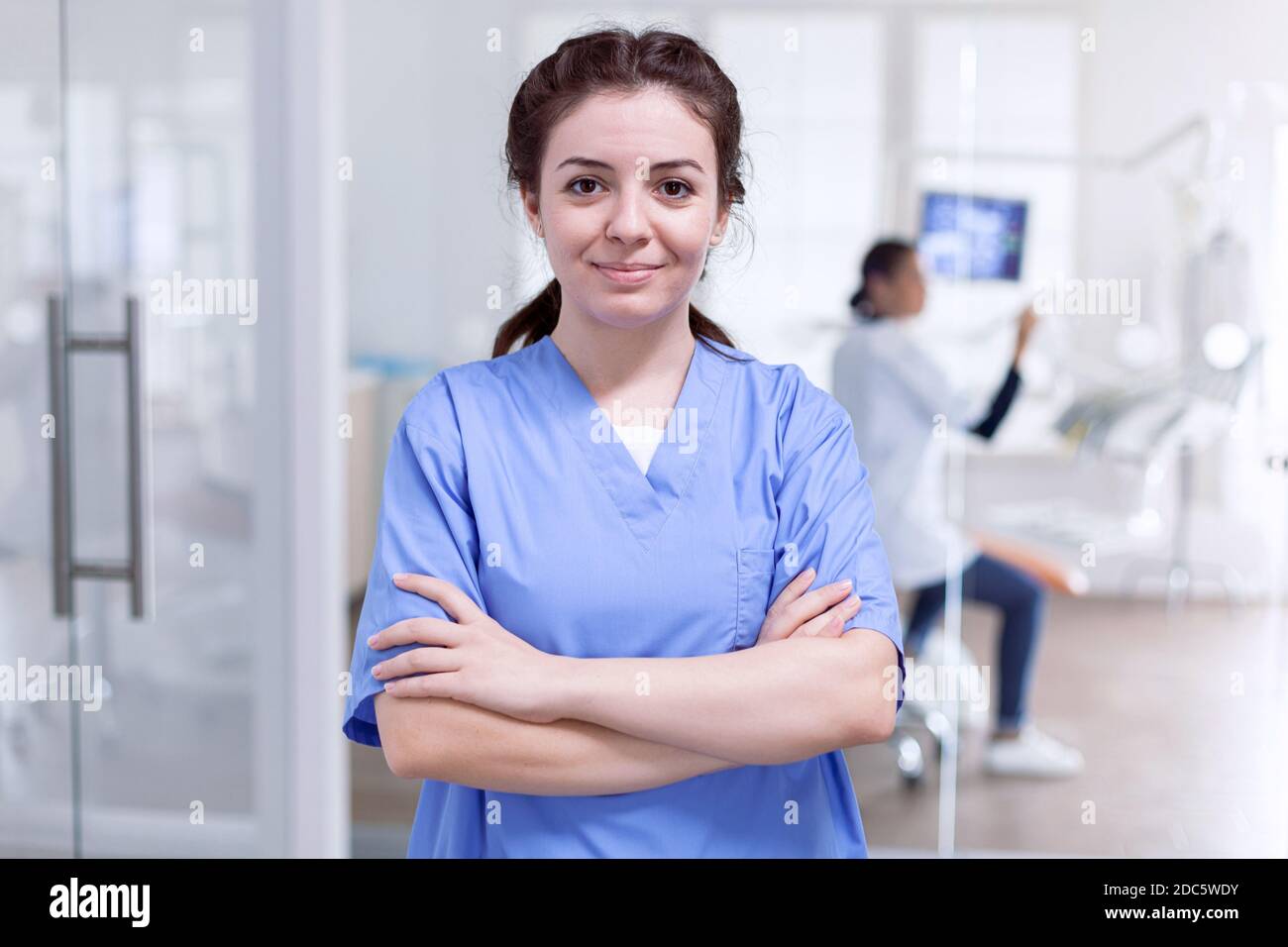 Portrait of stomatology nurse in dental reception with arms crossed
