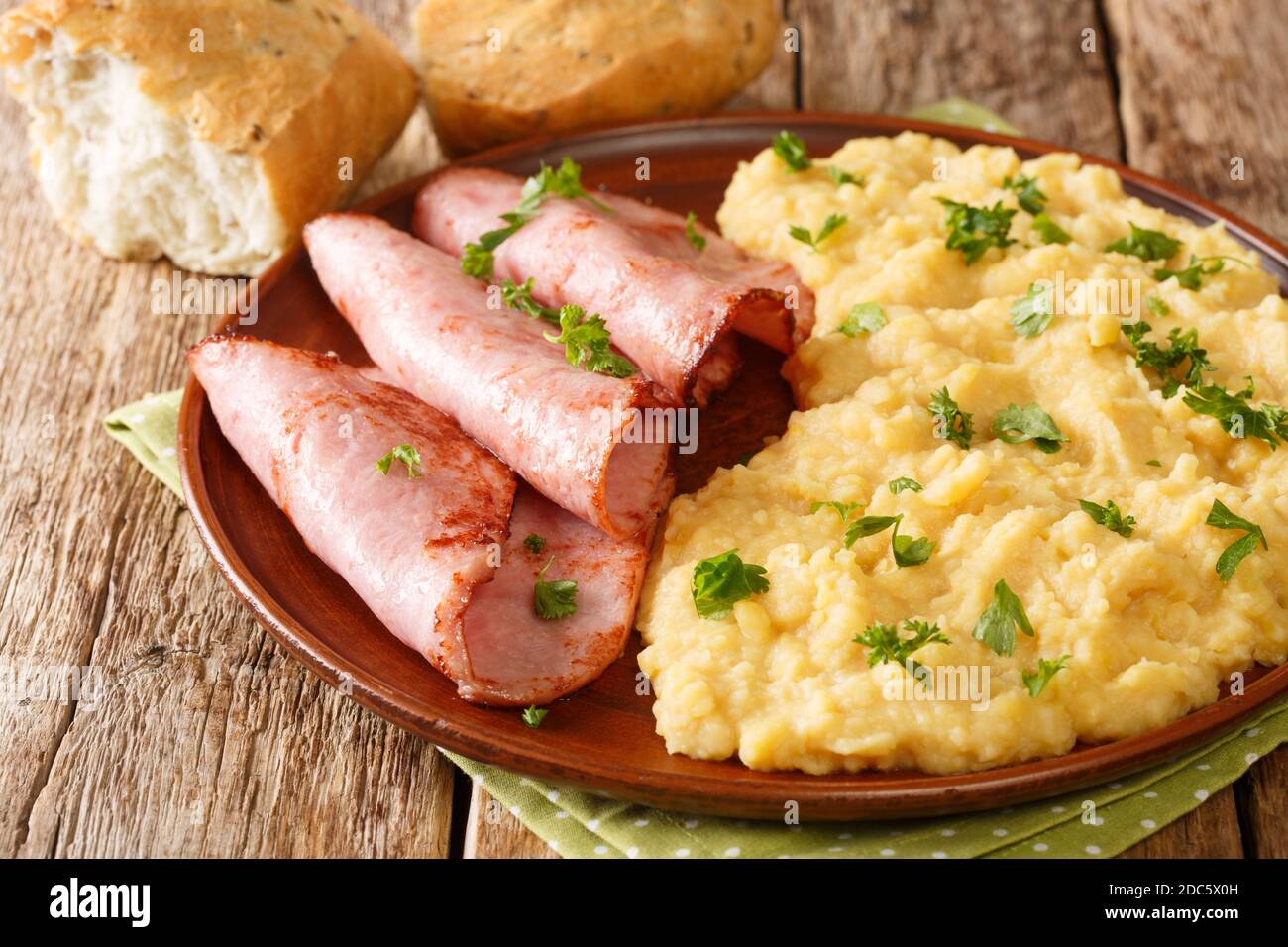 English pea pudding with fried ham served with bread close-up in a plate on the table. horizontal Stock Photo