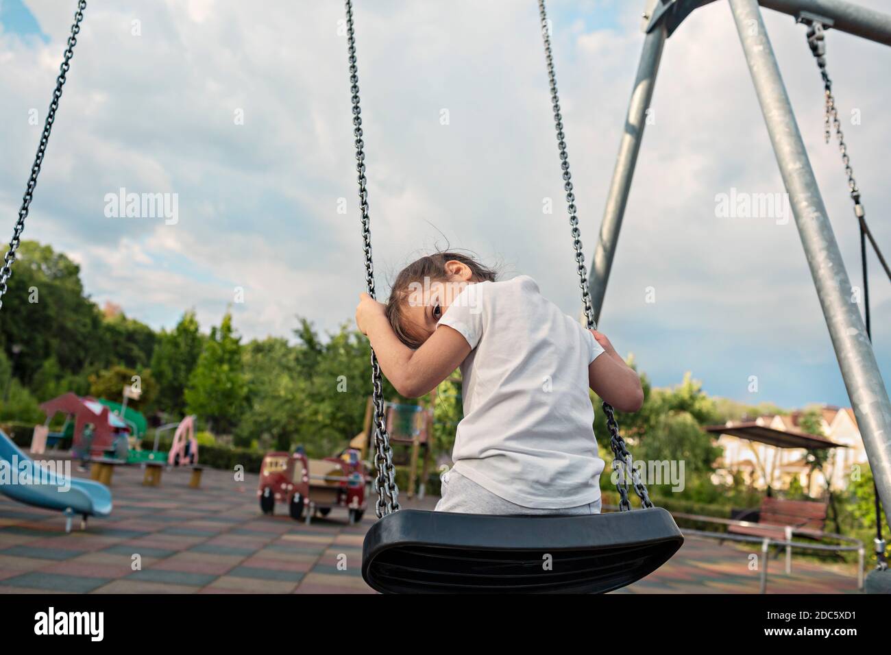 Portrait cute girl on swing at park playground Stock Photo - Alamy